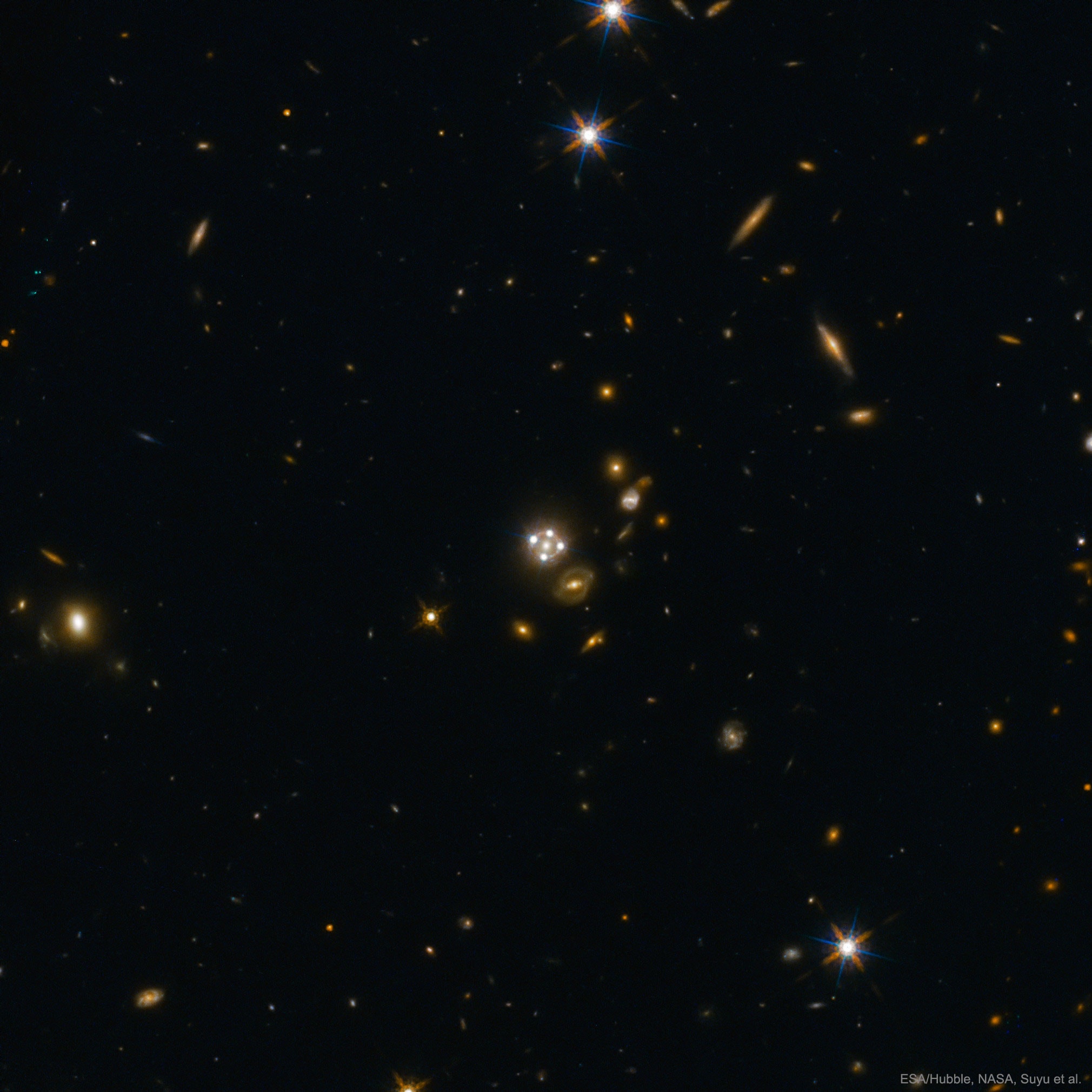 An odd thing about the group of lights near the center is that four of them are the same distant quasar.  This is because the foreground galaxy -- in the center of the quasar images and the featured image -- is acting like a choppy gravitational lens. A perhaps even odder thing is that by watching these background quasars flicker, you can estimate the expansion rate of the universe.  That is because the flicker timing increases as the expansion rate increases.  But to some astronomers, the oddest thing of all is that these multiply imaged quasars indicate a universe that is expanding a bit faster than has been estimated by different methods that apply to the early universe. And that is because ... well, no one is sure why.  Reasons might include an unexpected distribution of dark matter, some unexpected effect of gravity, or something completely different.  Perhaps future observations and analyses of this and similarly lensed quasar images will remove these oddities.