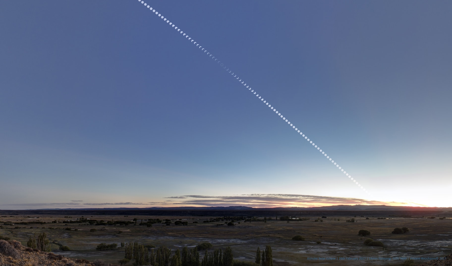 From northern Patagonia, morning skies were clear and blue on Sunday, February 26. This sweeping composite scene, overlooking Hermoso Valle, Facundo, Chubut, Argentina, follows the Sun after sunrise, capturing an annular solar eclipse. Created from a series of exposures at three minute intervals, it shows the year's first solar eclipse beginning well above the distant eastern horizon. An exposure close to mid-eclipse recorded the expected ring of fire, the silhouette of the New Moon only slightly too small to cover the bright Sun. At that location on planet Earth, the annular phase of the eclipse lasted a brief 45 seconds.