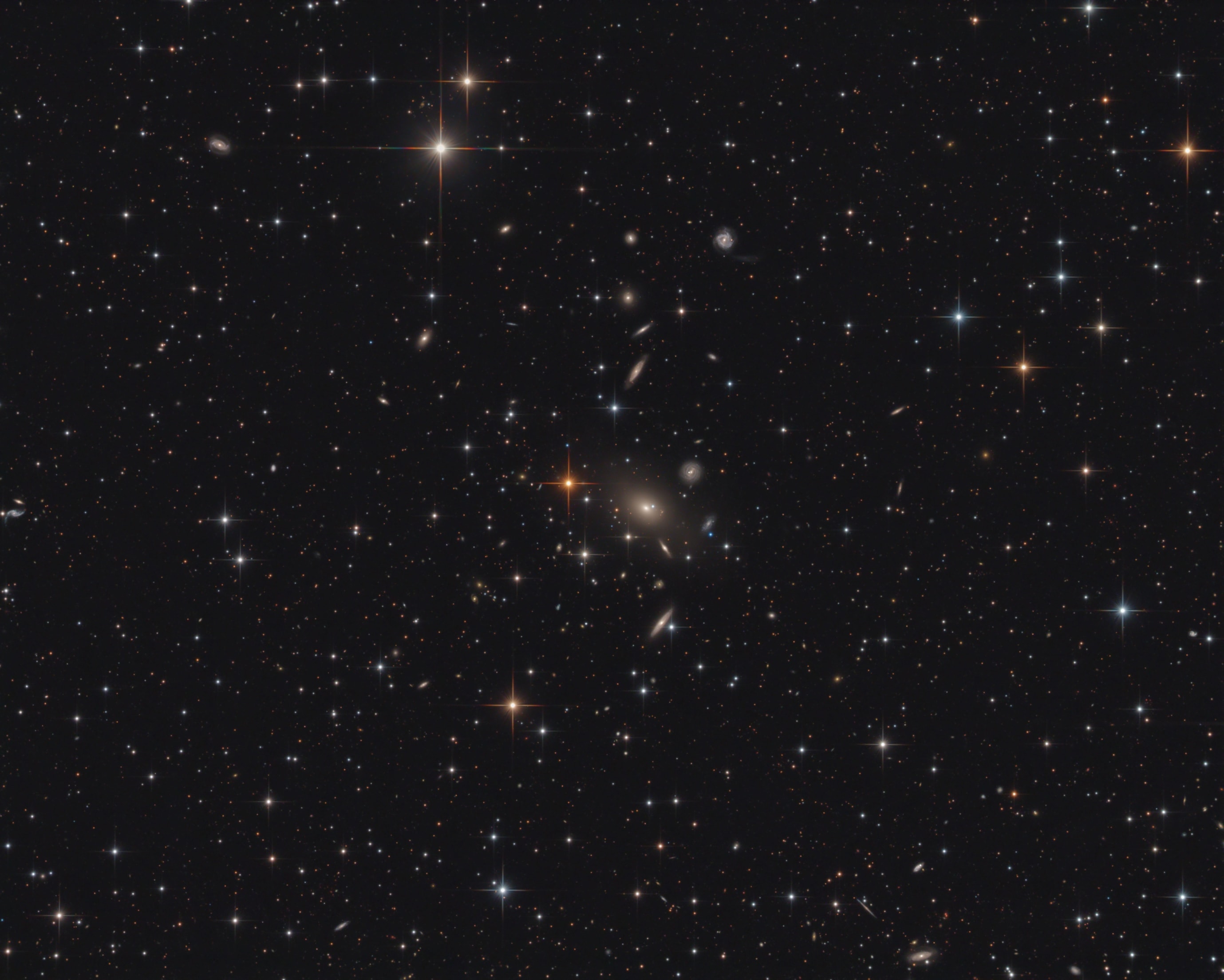 The galaxies of Abell 2666 lie far beyond the Milky Way, some 340 million light-years distant toward the high flying constellation Pegasus. Framed in this sharp telescopic image, the pretty cluster galaxies are gathered behind scattered, spiky, Milky Way stars. At cluster center is giant elliptical galaxy NGC 7768, the central dominant galaxy of the cluster. As the cluster forms, such massive galaxies are thought to grow by mergers of galaxies that fall through the center of the cluster's gravitational well. Typical of dominant cluster galaxies, NGC 7768 likely harbors a supermassive black hole. At the estimated distance of Abell 2666, this cosmic frame would span about 5 million light-years.
