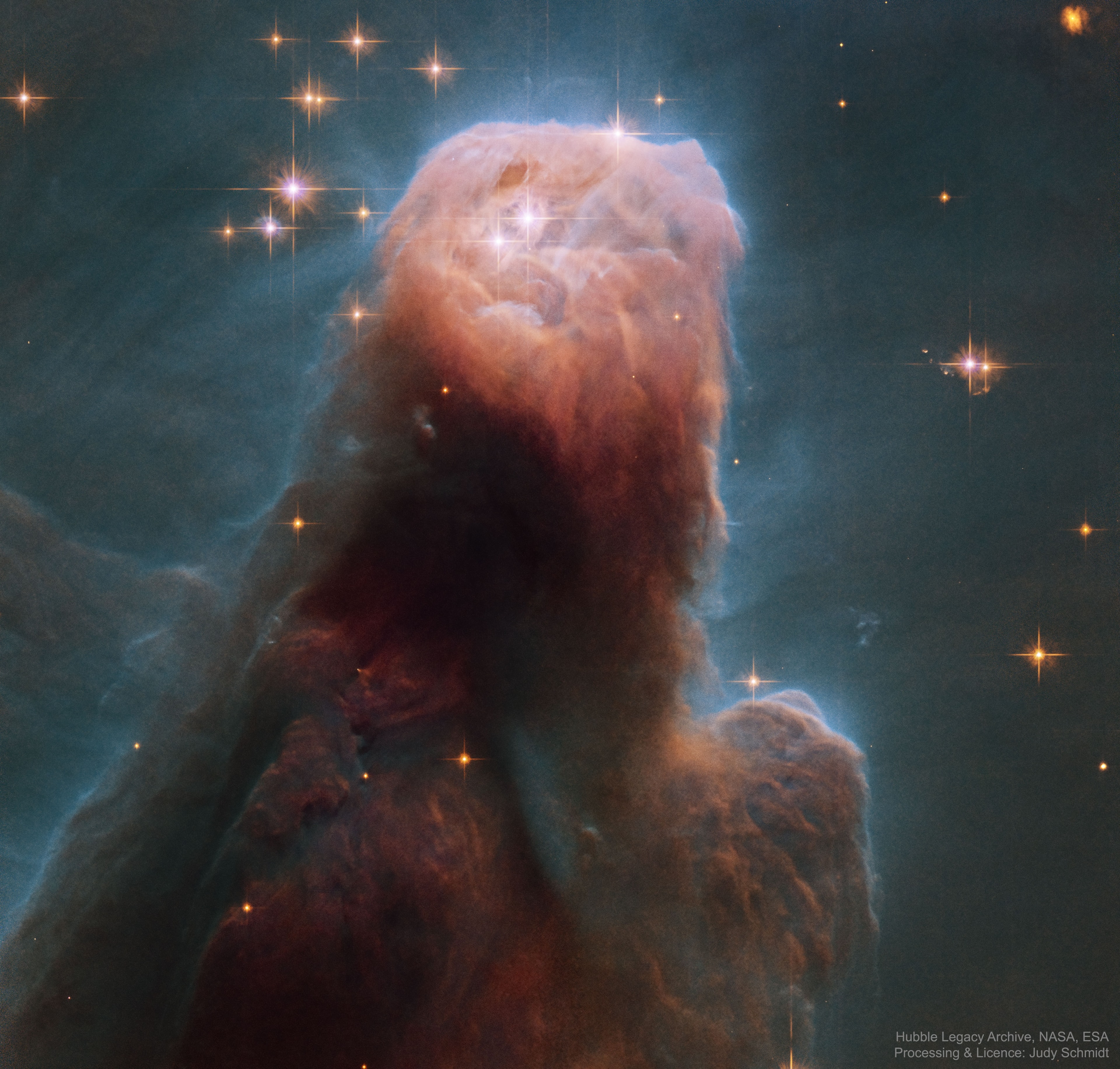 Stars are forming in the gigantic dust pillar called the Cone Nebula. Cones, pillars, and majestic flowing shapes abound in stellar nurseries where natal clouds of gas and dust are buffeted by energetic winds from newborn stars. The Cone Nebula, a well-known example, lies within the bright galactic star-forming region NGC 2264. The Cone was captured in unprecedented detail in this close-up composite of several observations from the Earth-orbiting Hubble Space Telescope. While the Cone Nebula, about 2,500 light-years away in Monoceros, is around 7 light-years long, the region pictured here surrounding the cone's blunted head is a mere 2.5 light-years across. In our neck of the galaxy that distance is just over half way from our Sun to its nearest stellar neighbors in the Alpha Centauri star system. The massive star NGC 2264 IRS, seen by Hubble's infrared camera in 1997, is the likely source of the wind sculpting the Cone Nebula and lies off the top of the image. The Cone Nebula's reddish veil is produced by glowing hydrogen gas.