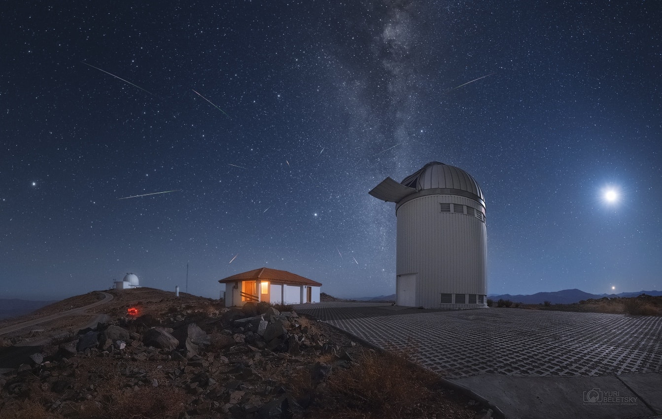 rth's annual Lyrid meteor shower peaked before dawn on April 22nd, as our fair planet plowed through dust from the tail of long-period comet Thatcher. Seen from the high, dark, and dry Atacama desert a waning crescent Moon and brilliant Venus join Lyrid meteor streaks in this composited view. Captured over 5 hours on the night of April 21/22, the meteors stream away from the shower's radiant, a point not very far on the sky from Vega, alpha star of the constellation Lyra. The radiant effect is due to perspective as the parallel meteor tracks appear to converge in the distance.  In the foreground are domes of the Las Campanas Observatory housing (left to right) the 2.5 meter du Pont Telescope and the 1.3 meter Optical Gravitational Lensing Experiment (OGLE) telescope.