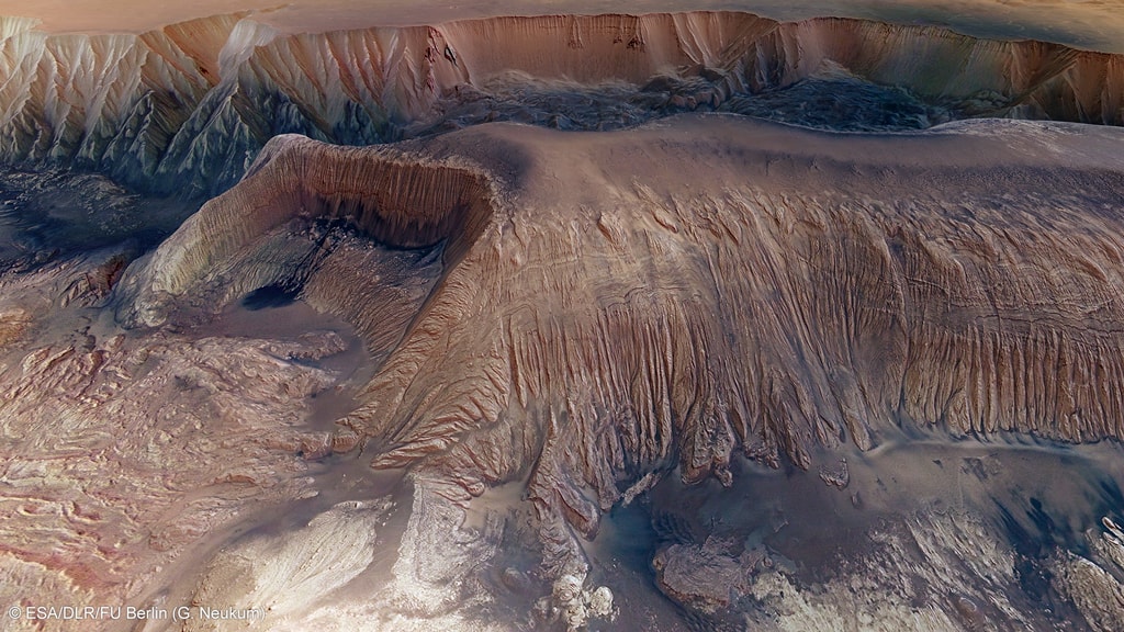 What's happened in Hebes Chasma on Mars? Hebes Chasma is a depression just north of the enormous Valles Marineris canyon.  Since the depression is unconnected to other surface features, it is unclear where the internal material went. Inside Hebes Chasma is Hebes Mensa, a 5 kilometer high mesa that appears to have undergone an unusual partial collapse -- a collapse that might be providing clues. The featured image, taken by ESA's robotic Mars Express spacecraft currently orbiting Mars, shows great details of the chasm and the unusual horseshoe shaped indentation in the central mesa. Material from the mesa appears to have flowed onto the floor of the chasm, while a possible dark layer appears to have pooled like ink on a downslope landing.  A recent hypothesis holds that salty rock composes some lower layers in Hebes Chasma, with the salt dissolving in melted ice flows that drained through holes into an underground aquifer.