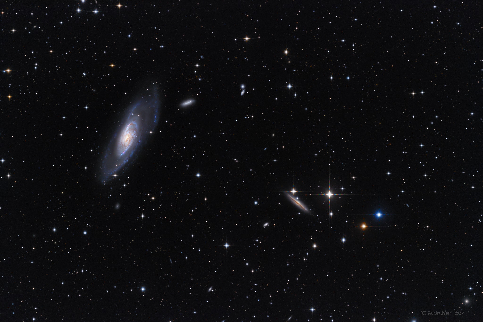 Big, bright, beautiful spiral, Messier 106 dominates this cosmic vista. The two degree wide telescopic field of view looks toward the well-trained constellation Canes Venatici, near the handle of the Big Dipper. Also known as NGC 4258, M106 is about 80,000 light-years across and 23.5 million light-years away, the largest member of the Canes II galaxy group. For a far away galaxy, the distance to M106 is well-known in part because it can be directly measured by tracking this galaxy's remarkable maser, or microwave laser emission. Very rare but naturally occuring, the maser emission is produced by water molecules in molecular clouds orbiting its active galactic nucleus. Another prominent spiral galaxy on the scene, viewed nearly edge-on, is NGC 4217 below and right of M106. The distance to NGC 4217 is much less well-known, estimated to be about 60 million light-years.