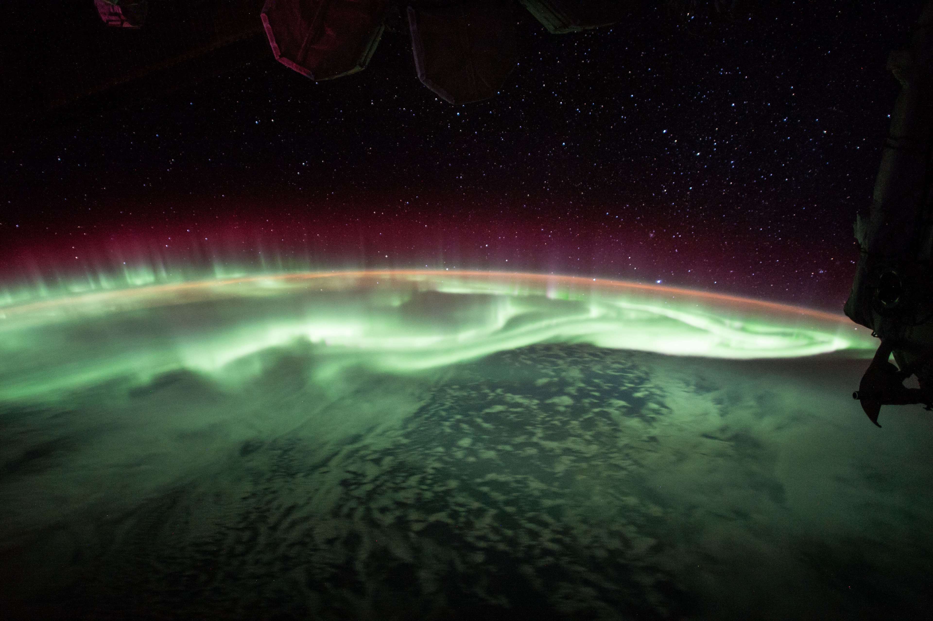 Like salsa verde on your favorite burrito, a green aurora slathers up the sky in this June 25 snapshot from the International Space Station. About 400 kilometers (250 miles) above Earth, the orbiting station is itself within the upper realm of the auroral displays. Aurorae have the signature colors of excited molecules and atoms at the low densities found at extreme altitudes. Emission from atomic oxygen dominates this view. The tantalizing glow is green at lower altitudes, but rarer reddish bands extend above the space station's horizon. The orbital scene was captured while passing over a point south and east of Australia, with stars above the horizon at the right belonging to the constellation Canis Major, Orion's big dog. Sirius, alpha star of Canis Major, is the brightest star near the Earth's limb.