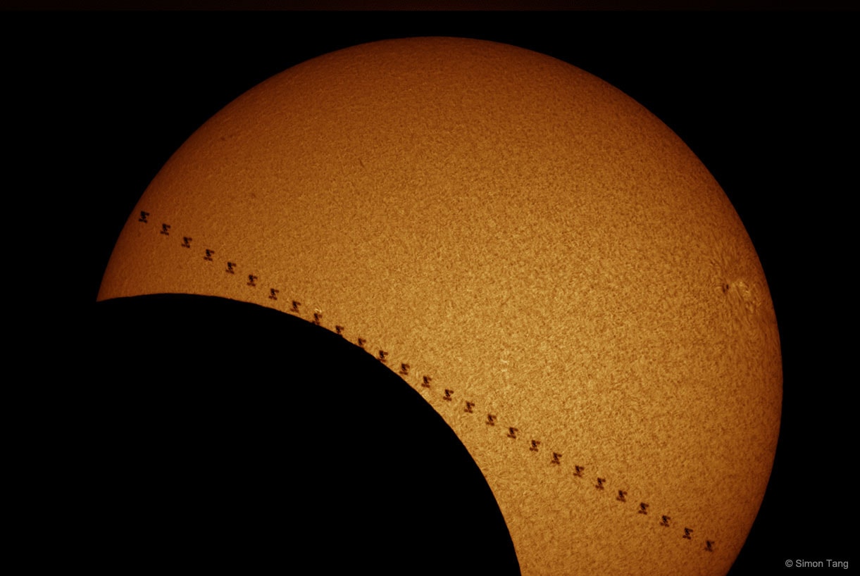 Last week, for a fraction of a second, the Sun was eclipsed twice. One week ago today, many people in North America were treated to a standard, single, partial solar eclipse. Fewer people, all congregated along a narrow path, experienced the eerie daytime darkness of a total solar eclipse.  A dedicated few with fast enough camera equipment, however, were able to capture a double eclipse -- a simultaneous partial eclipse of the Sun by both the Moon and the International Space Station (ISS). The Earth-orbiting ISS crossed the Sun in less than a second, but to keep the ISS from appearing blurry, exposure times must be less than 1/1000th of a second. The featured image composite captured the ISS multiple times in succession as it zipped across the face of the Sun. The picture was taken from Huron, California in a specific color emitted by hydrogen which highlights the Sun's chromosphere, a layer hotter and higher up than the usually photographed photosphere.    Follow APOD on: Facebook,  Google Plus,  Instagram, or Twitter