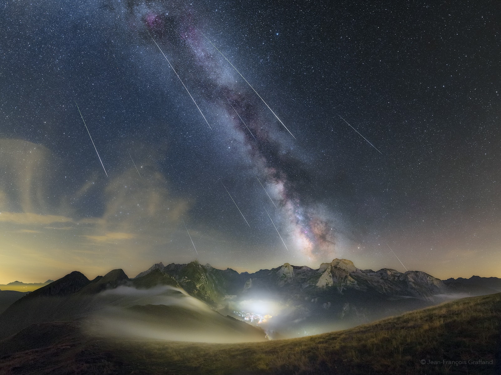 This mountain and night skyscape stretches across the French Pyrenees National Park on August 12, near the peak of the annual Perseid meteor shower. The multi-exposure panoramic view was composed from the Col d'Aubisque, a mountain pass, about an hour before the bright gibbous moon rose. Centered is a misty valley and lights from the region's Gourette ski station toward the south. Taken over the following hour, frames capturing some of the night's long bright perseid meteors were aligned against the backdrop of stars and Milky Way.
