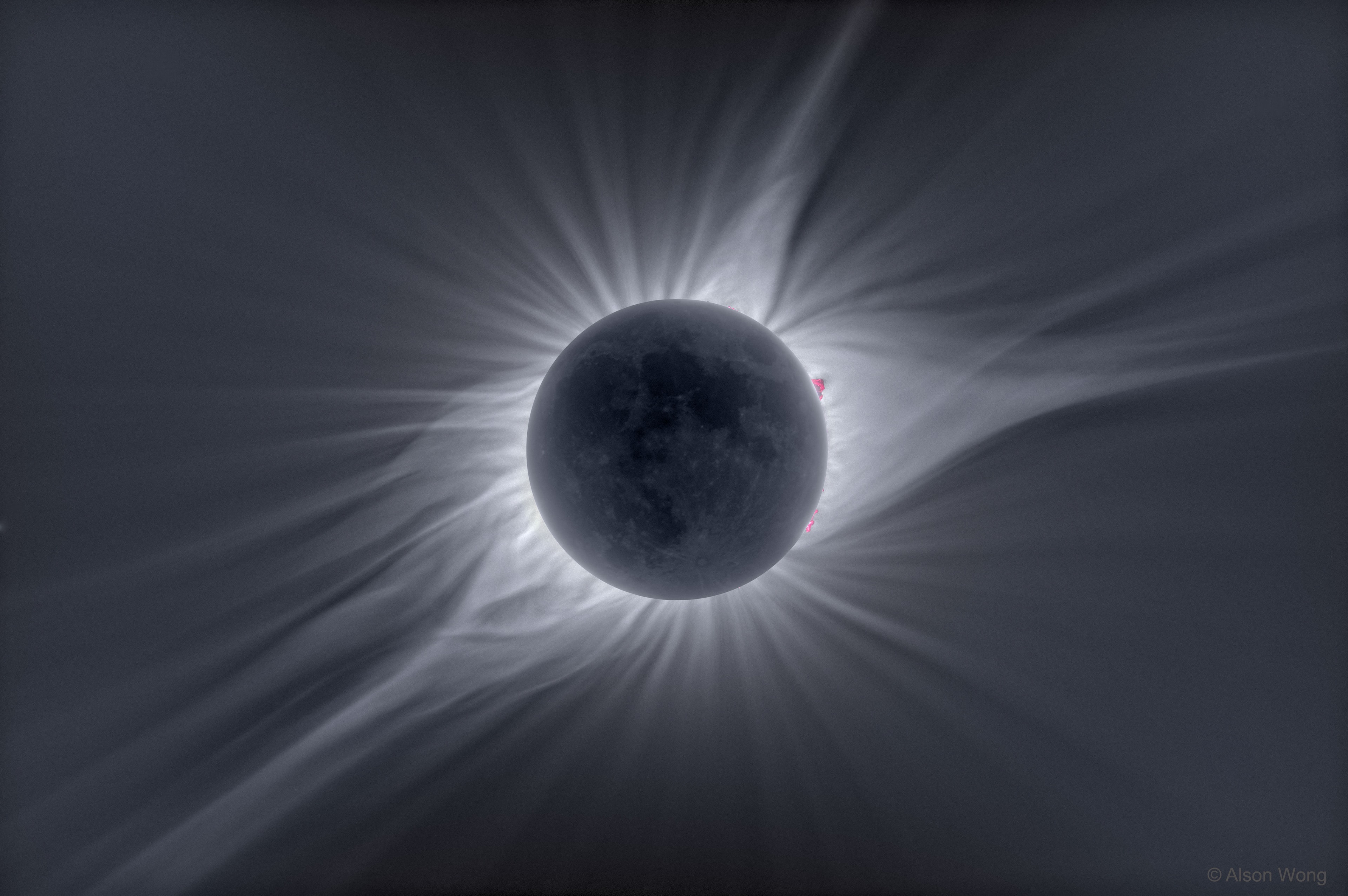 Most photographs don't adequately portray the magnificence of the Sun's corona. Seeing the corona first-hand during a total solar eclipse is unparalleled.  The human eye can adapt to see coronal features and extent that average cameras usually cannot. Welcome, however, to the digital age.  The featured picture is a combination of forty exposures from one thousandth of a second to two seconds that, together, were digitally combined and processed to highlight faint features of the total solar eclipse that occurred in August of 2017.  Clearly visible are intricate layers and glowing caustics of an ever changing mixture of hot gas and magnetic fields in the Sun's corona.  Looping prominences appear bright pink just past the Sun's limb.  Faint details on the night side of the New Moon can even be made out, illuminated by sunlight reflected from the dayside of the Full Earth.