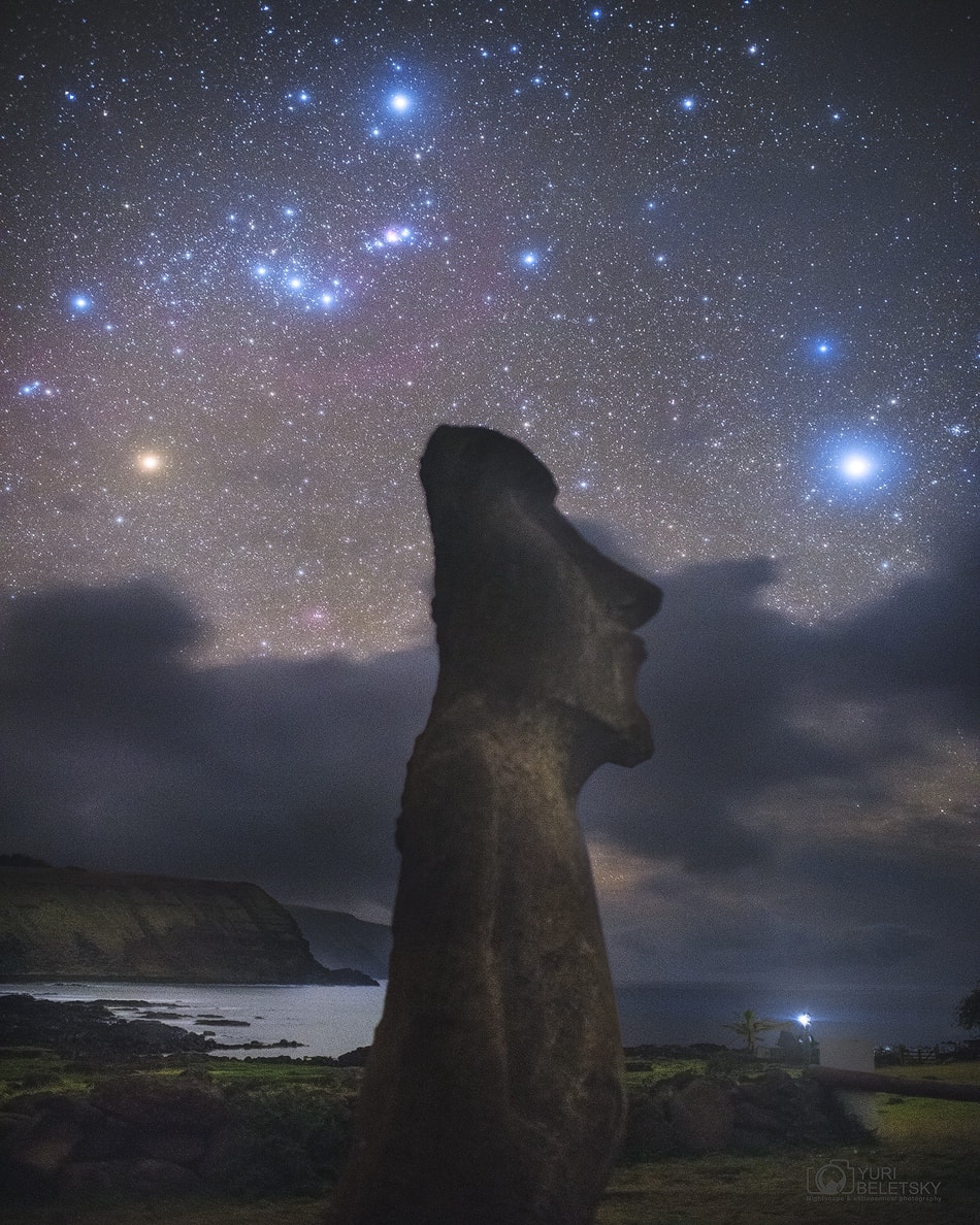 Why were the statues on Easter Island built? No one is sure.  What is sure is that over 800 large stone statues exist there.  The Easter Island statues, stand, on the average, over twice as tall as a person and have over 200 times as much mass.  Few specifics are known about the history or meaning of the unusual rock sculptures, but many believe that they were created about 700 years ago in the images of local leaders of a lost civilization.  Featured here, one of the ancient Moai sculptures was imaged in 2016 before the constellation of Orion, including the famous line of three belt stars and brilliant stars Betelgeuse (far left in red) and Rigel (upper center). The stone giant appears, however, to be inspecting the brightest star in the night sky (far right): Sirius.    Follow APOD on: Facebook,  Google Plus,  Instagram, or Twitter