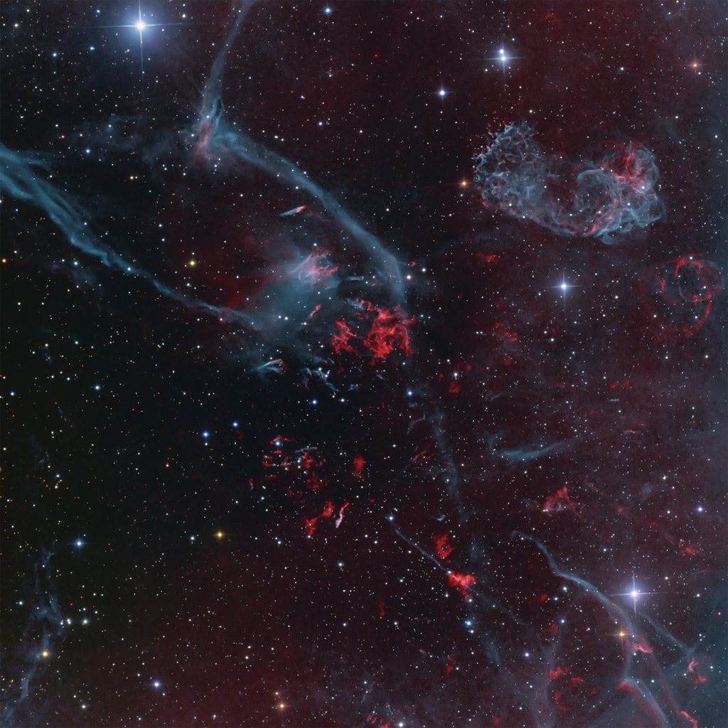 Driven by the explosion of a massive star, supernova remnant Puppis A is blasting into the surrounding interstellar medium about 7,000 light-years away. At that distance, this colorful telescopic field based on broadband and narrowband optical image data is about 60 light-years across. As the supernova remnant (upper right) expands into its clumpy, non-uniform surroundings, shocked filaments of oxygen atoms glow in green-blue hues. Hydrogen and nitrogen are in red. Light from the initial supernova itself, triggered by the collapse of the massive star's core, would have reached Earth about 3,700 years ago. The Puppis A remnant is actually seen through outlying emission from the closer but more ancient Vela supernova remnant, near the crowded plane of our Milky Way galaxy. Still glowing across the electromagnetic spectrum Puppis A remains one of the brightest sources in the X-ray sky.
