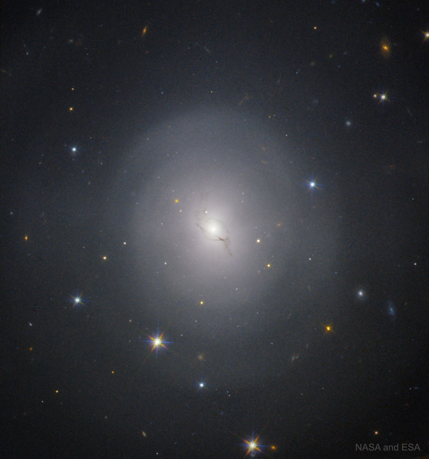 That reddish dot -- it wasn't there before.  It's the dot to the upper left of galaxy NGC 4993's center, do you see it?  When scanning the large field of possible locations of an optical counterpart to the unprecedented gravitational wave event GW170817 in August, the appearance of this fading dot quickly became of historic importance. It pinpointed GW170817's exact location, thereby enabling humanity's major telescopes to examine the first ever electromagnetic wave counterpart to a gravitational wave event, an event giving strong evidence of being a short gamma-ray burst kilonova, the element-forming explosion that occurs after two neutron stars merge. The featured image of lenticular galaxy NGC 4993 by Hubble shows the fading dot several days after it was discovered.  Analyses, continuing, include the physics of the explosion, what heavy elements formed, the similarity of the speeds of gravitational radiation and light, and calibrating a new method for determining the distance scale of our universe.    More on GW170817: Journal articles, data, graphics