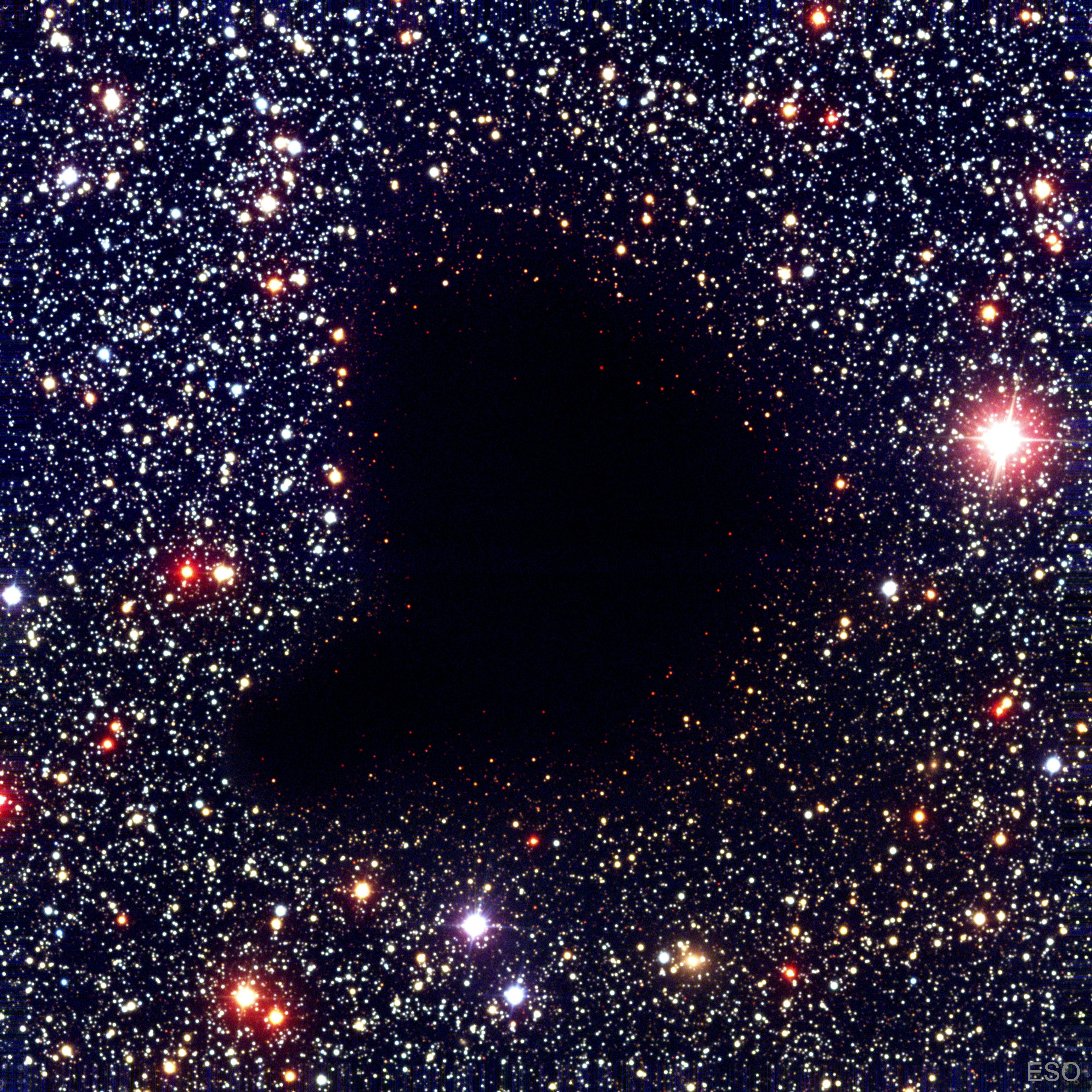 Where did all the stars go?  What used to be considered a hole in the sky is now known to astronomers as a dark molecular cloud.  Here, a high concentration of dust and molecular gas absorb practically all the visible light emitted from background stars.  The eerily dark surroundings help make the interiors of molecular clouds some of the coldest and most isolated places in the universe.  One of the most notable of these dark absorption nebulae is a cloud toward the constellation Ophiuchus known as Barnard 68, pictured here.  That no stars are visible in the center indicates that Barnard 68 is relatively nearby, with measurements placing it about 500 light-years away and half a light-year across.  It is not known exactly how molecular clouds like Barnard 68 form, but it is known that these clouds are themselves likely places for new stars to form. In fact, Barnard 68 itself has been found likely to collapse and form a new star system. It is possible to look right through the cloud in infrared light.