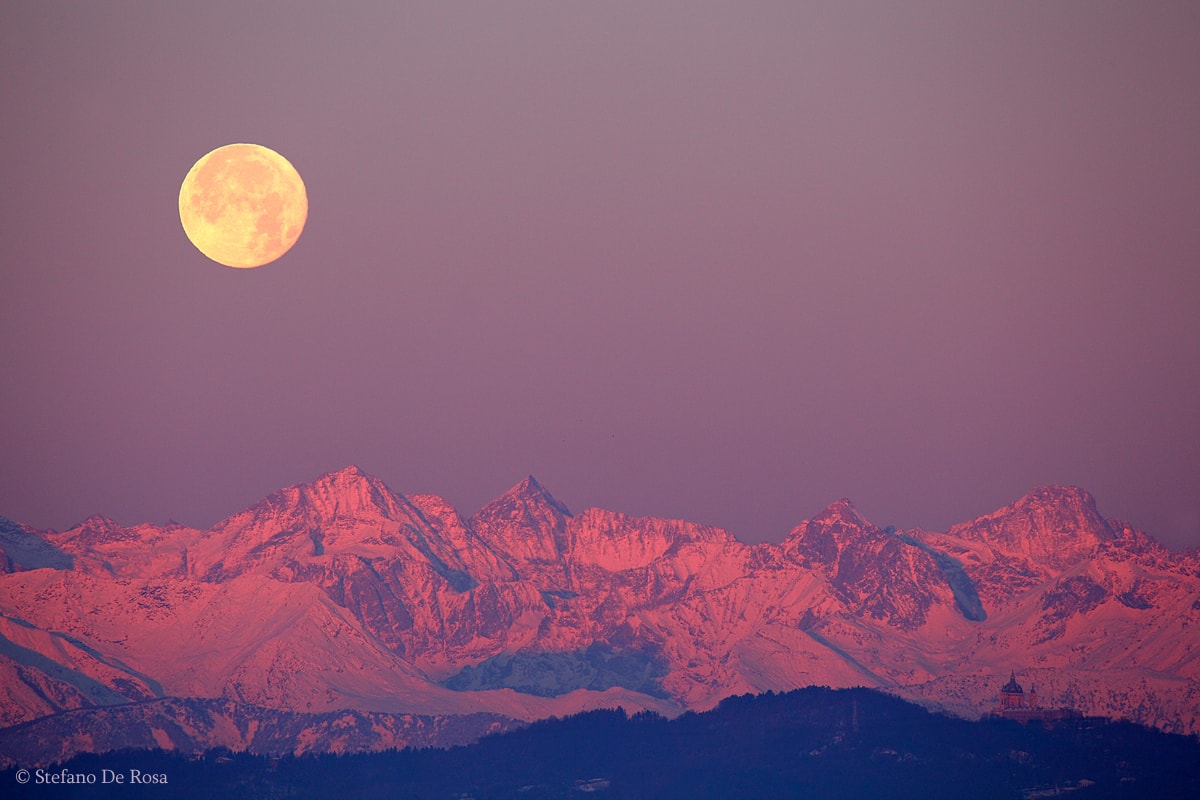 December's Full Moon phase occurred near perigee, the closest point in its orbit around our fair planet. Big and bright, the fully illuminated lunar disk sets over rugged mountains in this early morningscape from Turin, Italy. Captured just before sunrise on the opposite horizon, scattered sunlight near the edge of Earth's shadow provides the beautiful reddish glow of the alpine peaks. Hills in the foreground are still in shadow. But the scattered sunlight just illuminates the dome and towers of Turin's historic Basilica of Superga on a hilltop near the lower right in the telephoto frame.