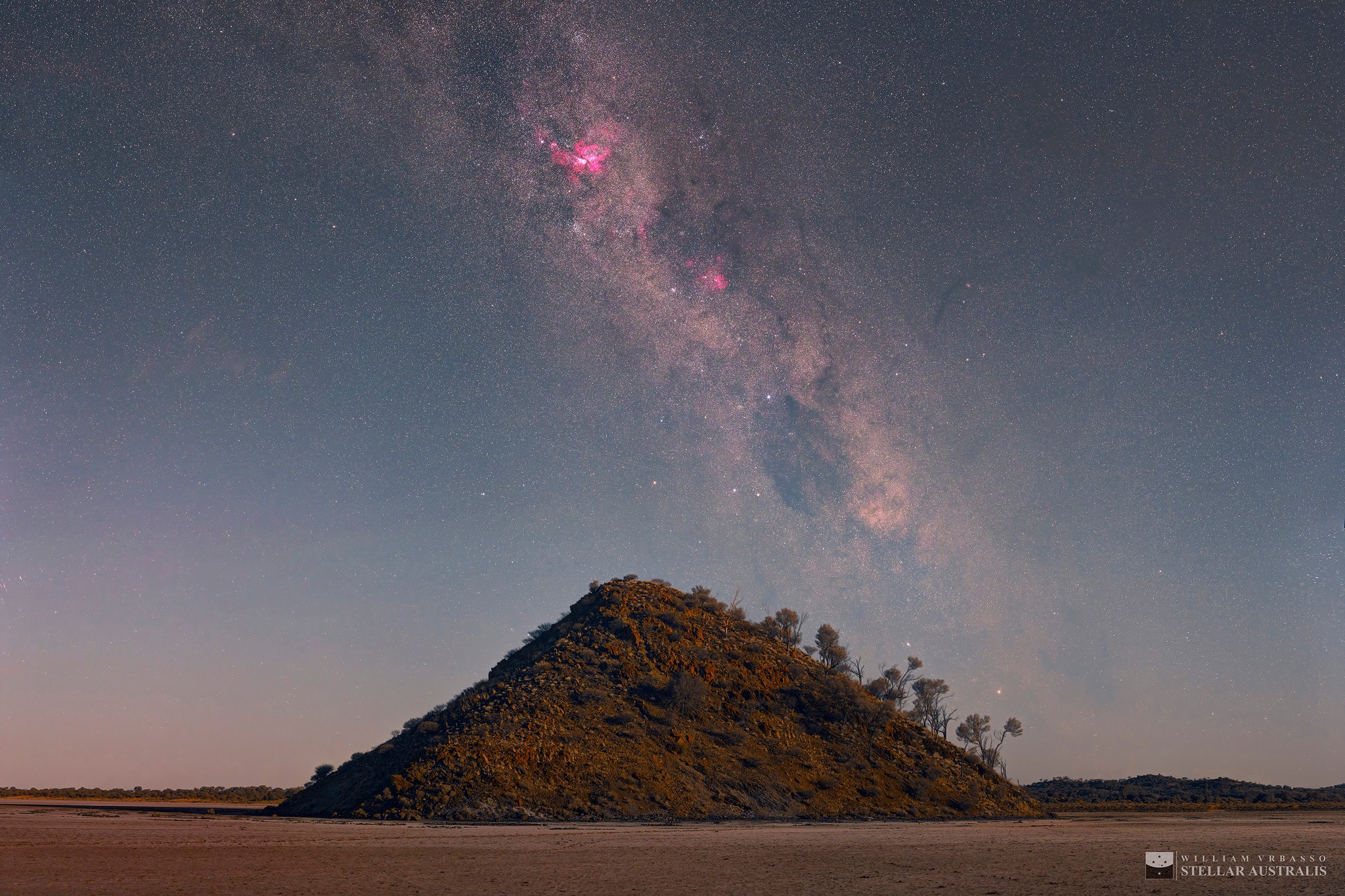 A jewel of the southern sky, the Great Carina Nebula, also known as NGC 3372, is one of our galaxy's largest star forming regions. Easily visible to the unaided eye it stands high above the signature hill of Lake Ballard, ephemeral salt lake of Western Australia, in this serene night skyscape from December 25, 2017. The Milky Way itself stretches beyond the southern horizon. Along the Milky Way, bright stars Alpha and Beta Centauri lie just above the hill's right flank, with the Southern Cross and dark Coalsack Nebula above the hill top. Based on a 22 panel mosaic, the scene was cropped to reveal more closely the beauty of this region of the southern Milky Way. On that short summer night, a star tracking camera mount was used to record the mosaic images of the sky, but turned off to image the foreground in moonlight.