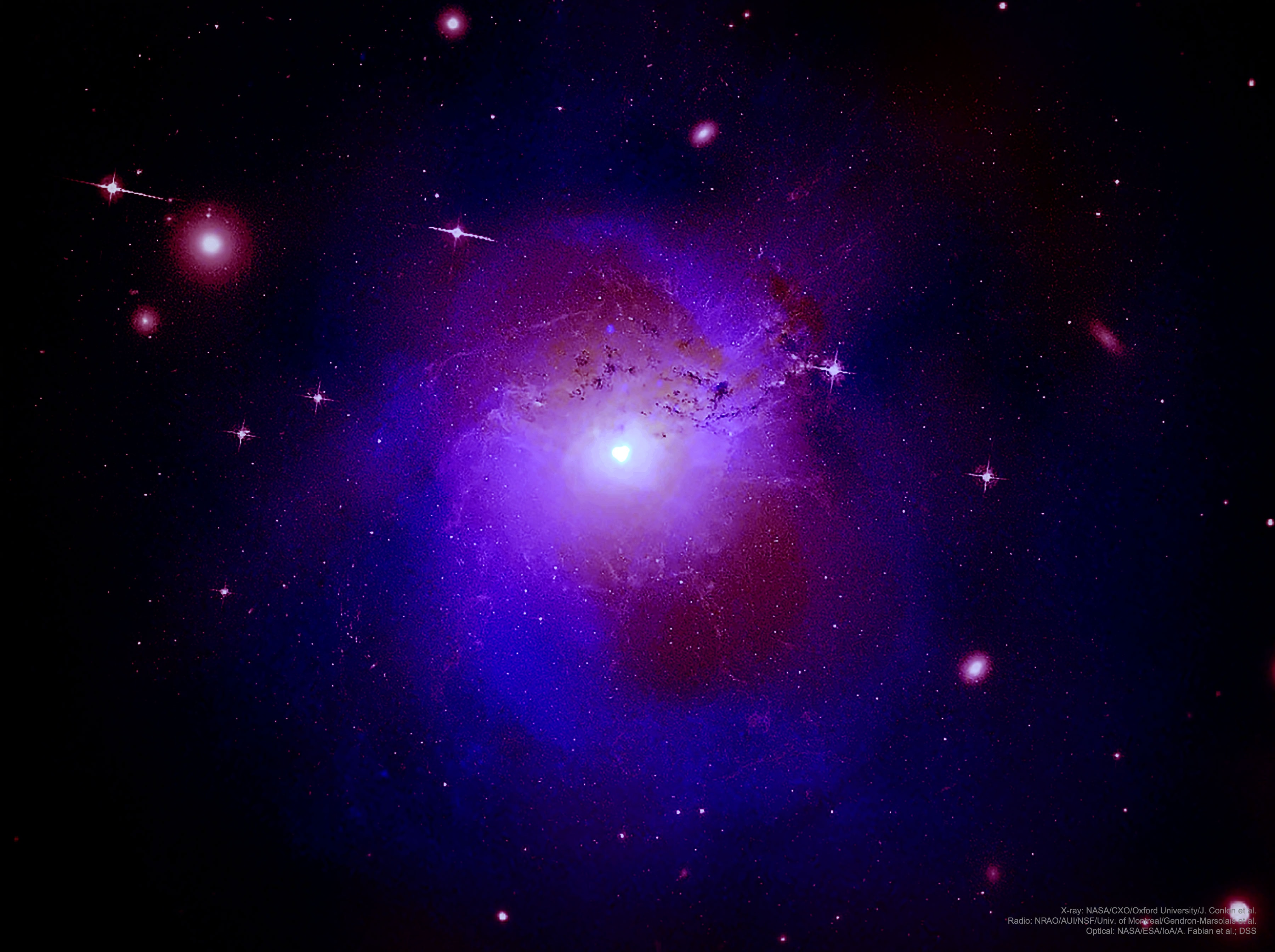 Why does the Perseus galaxy cluster shine so strangely in one specific color of X-rays? No one is sure, but a much-debated hypothesis holds that these X-rays are a clue to the long-sought identity of dark matter. At the center of this mystery is a 3.5 Kilo-electronvolt (KeV) X-ray color that appears to glow excessively only when regions well outside the cluster center are observed, whereas the area directly surrounding a likely central supermassive black hole is actually deficient in 3.5 keV X-rays. One proposed resolution -- quite controversial -- is that something never seen before might be present: fluorescent dark matter (FDM). This form of particle dark matter might be able to absorb 3.5 keV X-radiation.  If operating, FDM, after absorption, might later emit these X-rays from all over the cluster, creating an emission line. However, when seen superposed in front of the central region surrounding the black hole, FDM's absorption would be more prominent, creating an absorption line.  Pictured, a composite image of the Perseus galaxy cluster shows visible and radio light in red, and X-ray light from the Earth-orbiting Chandra Observatory in blue.    Free APOD Lectures: January 5 in NYC & January 9 in DC