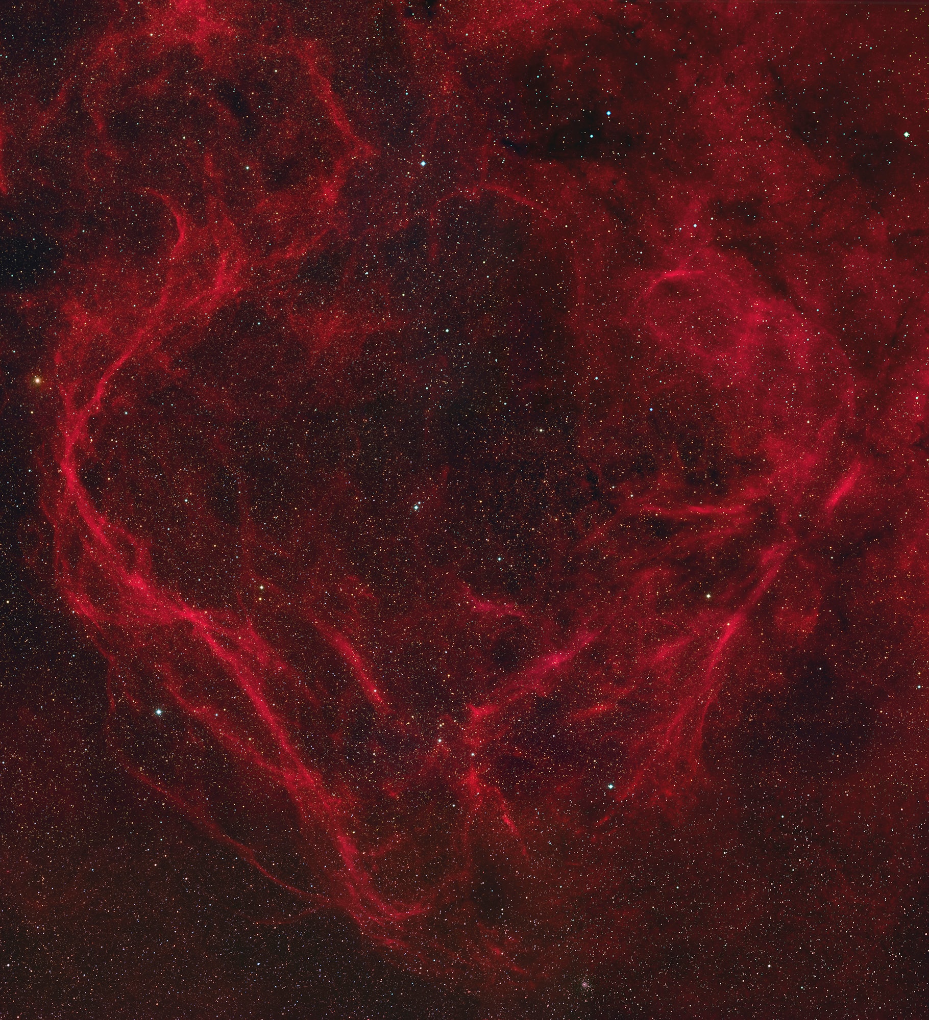 Large and dramatically shaped, this cosmic cloud spans nearly 7 degrees or 14 full moons across planet Earth's sky toward the southern constellation Ara. Difficult to image, the filamentary apparition is cataloged as RCW 114 and traced in this telescopic mosaic by the telltale reddish emission of ionized hydrogen atoms. In fact, RCW 114 has been recognized as a supernova remnant. Its extensive filaments of emission are produced as the still expanding shockwave from the death explosion of a massive star sweeps up the surrounding interstellar medium. Consistent estimates place its distance at over 600 light-years, indicating a diameter of about 100 light-years or so. Light from the supernova explosion that created RCW 114 would have reached Earth around 20,000 years ago. A spinning neutron star or pulsar has recently been identified as the remains of the collapsed stellar core.