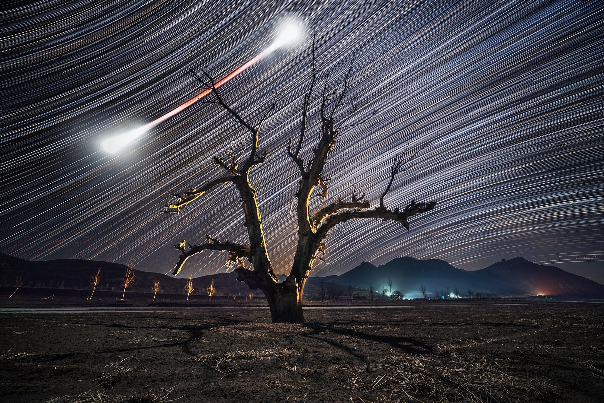 On January 31, a leisurely lunar eclipse was enjoyed from all over the night side of planet Earth, the first of three consecutive total eclipses of the Moon. This dramatic time-lapse image followed the celestial performance for over three hours in a combined series of exposures from Hebei Province in Northern China. Fixed to a tripod, the camera records the Full Moon sliding through a clear night sky.  Too bright just before and after the eclipse, the Moon's bow tie-shaped trail grows narrow and red during the darker total eclipse phase that lasted an hour and 16 minutes. In the distant background are the colorful trails of stars in concentric arcs above and below the celestial equator.