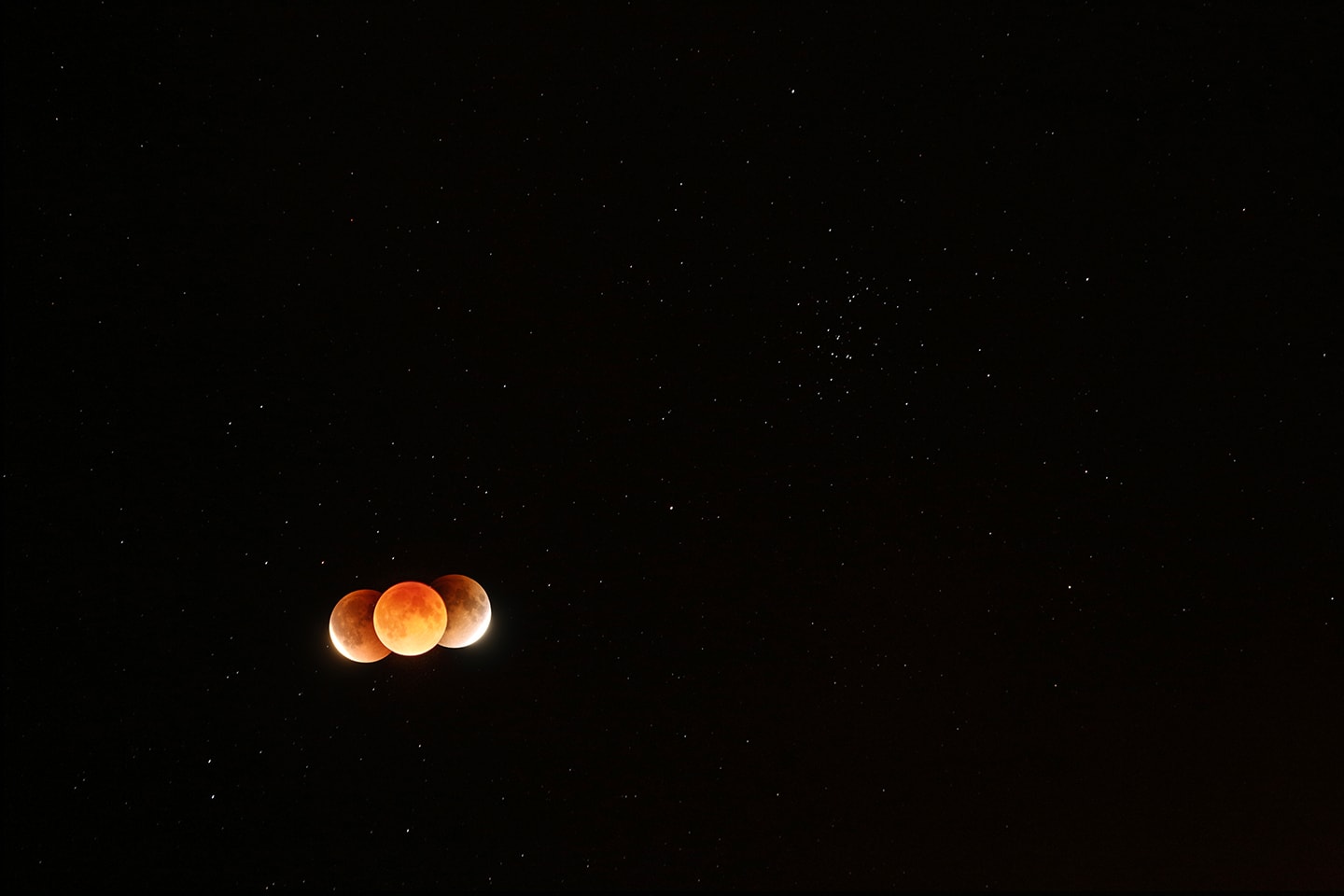 The Earth's dark umbral shadow is shaped like a cone extending into space. Of course its circular cross section at the distance of the Moon is more easily seen during a lunar eclipse. In fact, in this composite telephoto image from Earth's night side on January 31, the Earth's shadow has taken on a reddish tinge. The extent of the shadow along the lunar orbit is illustrated by aligning three frames taken just before the start, near the middle of, and just after the end of the total eclipse phase that lasted about 76 minutes. At the upper right and more easily seen during the eclipse's darker total phase is M44, one of the closest large star clusters. A mere 600 light-years away, M44 is also known as the Praesepe or the Beehive Cluster.