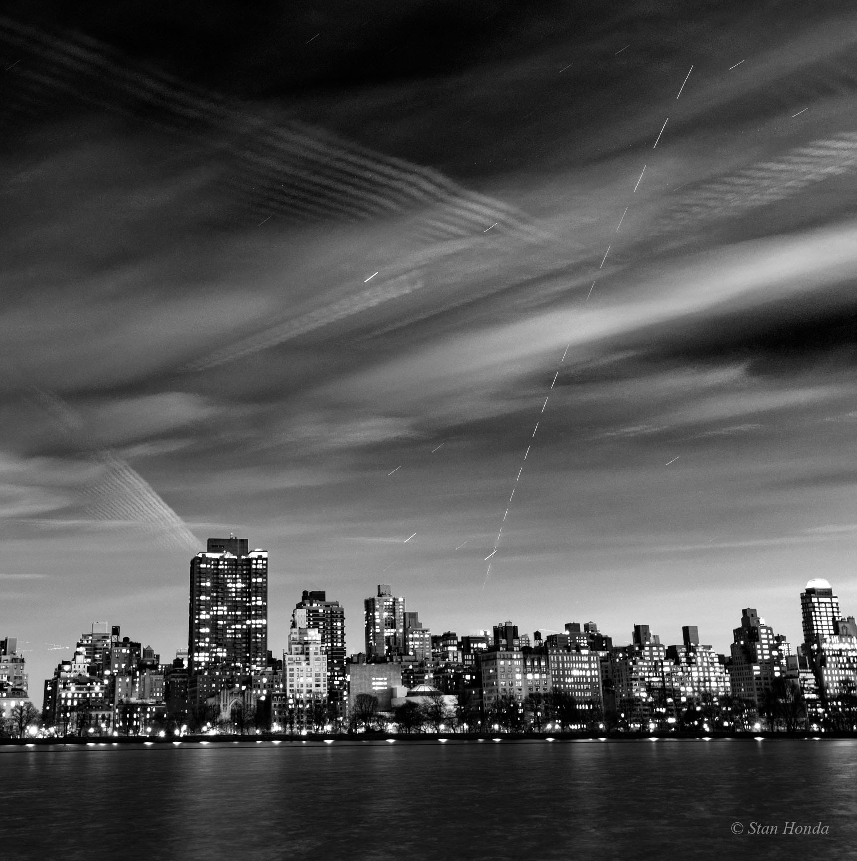 City lights shine along the upper east side of Manahattan in this dramatic urban night skyscape from February 13. Composed from a series of digital exposures, the monochrome image is reminiscent of the time when sensitive black and white film was a popular choice for dimly lit night and astro-photography. Spanning 2 minutes and 40 seconds, the combined 22 frames look across the reservoir in New York City's Central Park. Stars trail in the time-lapse view while drifting clouds make patterns in the sky. Traced from top to bottom, the dashed line in the surreal scene is the International Space Station still in sunlight and heading for the southeast horizon. The short time intervals between the exposures leave gaps in the space station's bright trail.