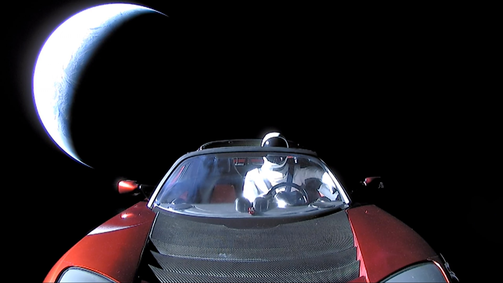 Don't panic. It's just a spacesuited mannequin named Starman. As the sunlit crescent of planet Earth recedes in the background, Starman is comfortably seated at the wheel of a Tesla Roadster in this final image of the payload launched by a Falcon Heavy rocket on February 6. Internationally designated 2018-017A, roadster and Starman are headed for space beyond the orbit of Mars. The successful Falcon Heavy rocket has now become the most powerful rocket in operation and the roadster one of four electric cars launched from planet Earth. The other three were launched to the Moon by historically more powerful (but not reusable) Saturn V rockets. Still, Starman's roadster is probably the only one that would be considered street legal.