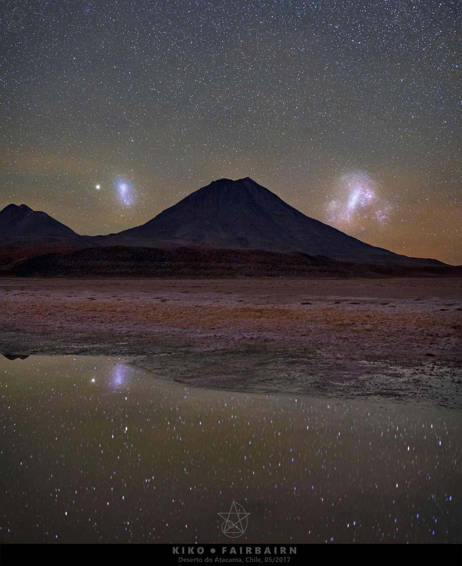 Flanked by satellite galaxies of the Milky Way a volcanic peak rises from this rugged horizon. The southern night skyscape looks toward the south over Laguna Lejia and the altiplano of the Antofagasta Region of northern Chile. Extending the view across extragalactic space, the Large (right) and Small Magellanic Clouds are so named for the 16th century Portuguese explorer Ferdinand Magellan, leader of planet Earth's first circumnavigation. The larger cloud lies some 180,000 light-years, and the smaller 210,000 light-years beyond the mountaintop. Left of the Small Cloud of Magellan and also reflected in the foreground watery shallows on that starry night, 47 Tucanae shines like a bright star. A globular star cluster that roams the halo of the Milky Way, 47 Tucanae is about 13,000 light-years away.