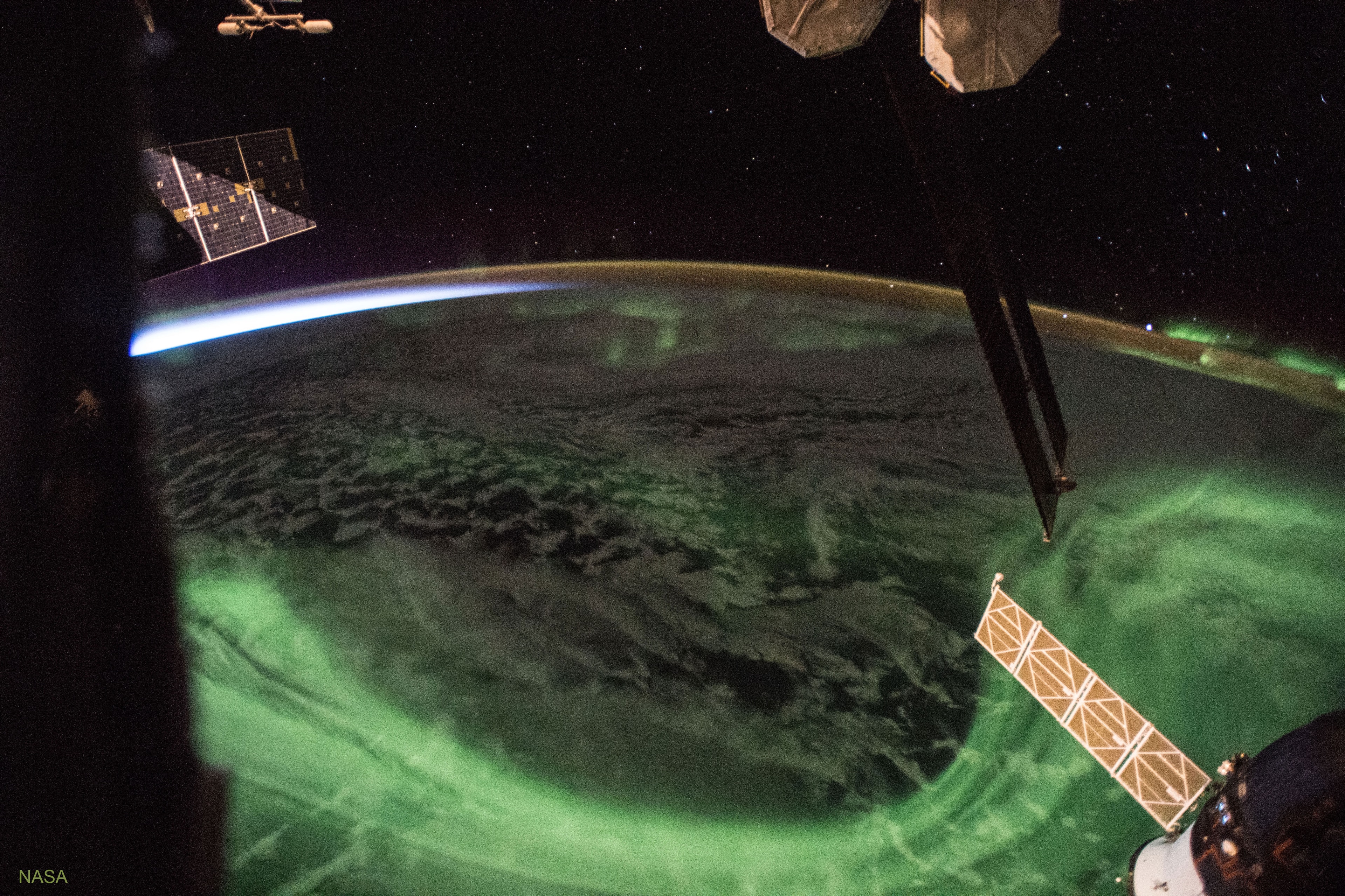 On the International Space Station (ISS), you can only admire an aurora until the sun rises. Then the background Earth becomes too bright.  Unfortunately, after sunset, the rapid orbit of the ISS around the Earth means that sunrise is usually less than  47 minutes away.  In the featured image, a green aurora is visible below the ISS -- and on the horizon to the upper right, while sunrise approaches ominously from the upper left.  Watching an aurora from space can be mesmerizing as its changing shape has been compared to a giant green amoeba.  Auroras are composed of energetic electrons and protons from the Sun that impact the Earth's magnetic field and then spiral down toward the Earth so fast that they cause atmospheric atoms and molecules to glow.  The ISS orbits at nearly the same height as auroras, many times flying right through an aurora's thin upper layers, an event that neither harms astronauts nor changes the shape of the aurora.    Share the Sky: NASA Open API for APOD