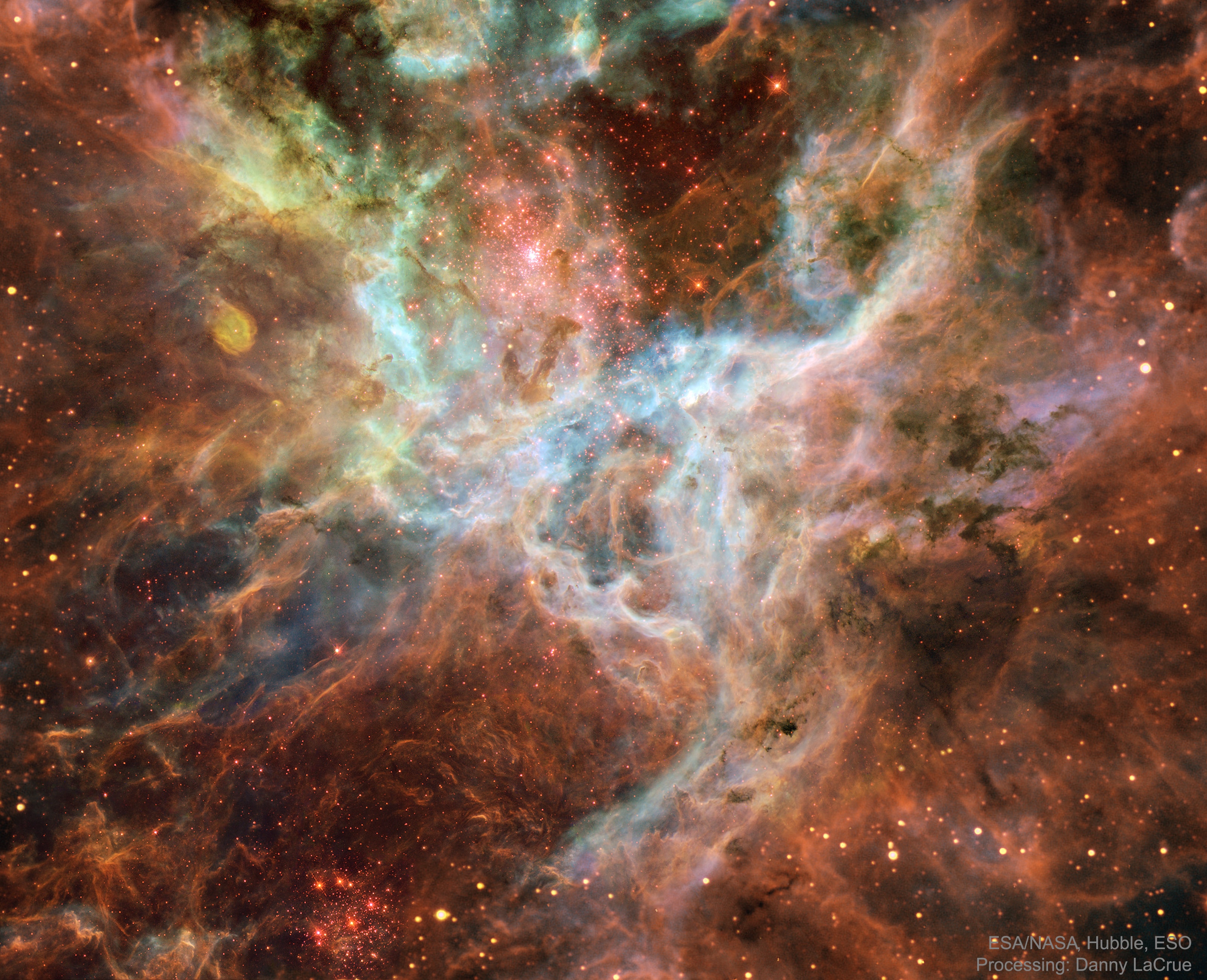 In the heart of monstrous Tarantula Nebula lies huge bubbles of energetic gas, long filaments of dark dust, and unusually massive stars. In the center of this heart, is a knot of stars so dense that it was once thought to be a single star. This star cluster, labeled as R136 or NGC 2070, is visible just above the center of the featured image and home to a great number of hot young stars.  The energetic light from these stars continually ionizes nebula gas, while their energetic particle wind blows bubbles and defines intricate filaments.  The representative-color picture, a digital synthesis of images from the NASA/ESA orbiting  Hubble Space Telescope and ESO's ground-based New Technology Telescope, shows great details of the LMC nebula's tumultuous center. The Tarantula Nebula, also known as the 30 Doradus nebula, is one of the largest star-formation regions known, and has been creating unusually strong episodes of star formation every few million years.