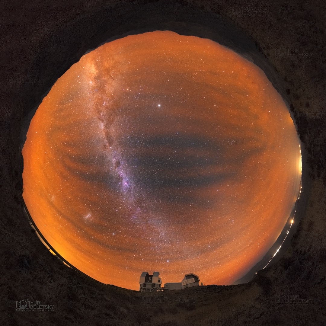 Captured last week after sunset on a Chilean autumn night, an exceptional airglow floods this allsky view from Las Campanas Observatory. The airglow was so intense it diminished parts of the Milky Way as it arced horizon to horizon above the high Atacama desert. Originating at an altitude similar to aurorae, the luminous airglow is due to chemiluminescence, the production of light through chemical excitation. Commonly recorded in color by sensitive digital cameras, the airglow emission here is fiery in appearance. It is predominately from atmospheric oxygen atoms at extremely low densities and has often been present during southern hemisphere nights over the last few years. Like the Milky Way, on that dark night the strong airglow was very visible to the eye, but seen without color. Jupiter is the brightest celestial beacon though, standing opposite the Sun and near the central bulge of the Milky Way rising above the eastern (top) horizon. The Large and Small Magellanic clouds both shine through the airglow to the lower left of the galactic plane, toward the southern horizon.