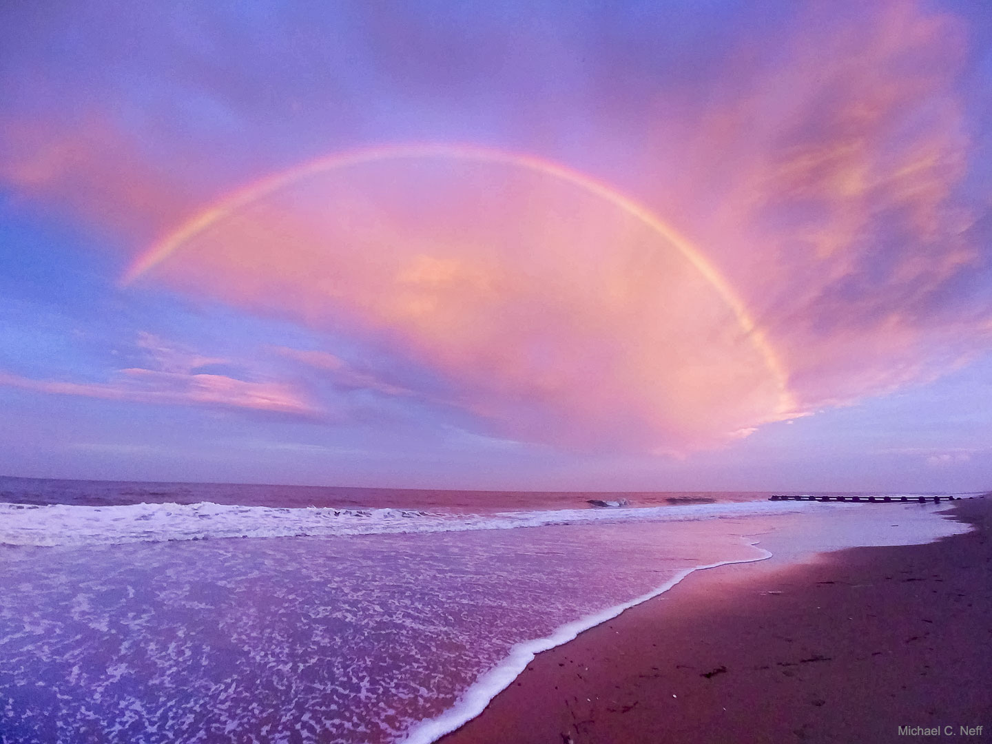 What kind of rainbow is this? In this case, no rain was involved -- what is pictured is actually a red cloudbow. The unusual sky arc was spotted last month during sunset in Rehoboth Beach, Delaware, USA. When the photographer realized that what he was seeing was extraordinary, he captured it with the only camera available -- a cell phone.  Clouds are made of water droplets, and in a cloudbow a cloud-droplet group reflects back light from the bright Sun (or Moon) on the opposite side of the sky.  Similar phenomena include fogbows and airplane glories. Here, the red color was caused by atmospheric air preferentially scattering away blue light -- which simultaneously makes most of the sky appear blue. A careful inspection reveals a supernumery bow just inside the outermost arc, a bow caused by quantum diffraction.   Open Science: Browse 1,700+ codes in the Astrophysics Source Code Library