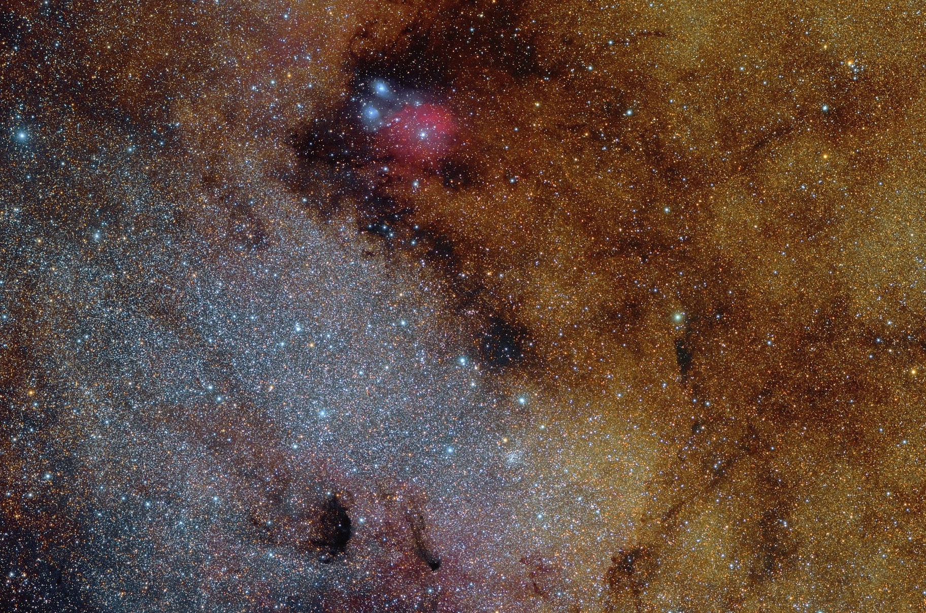 Unlike most entries in Charles Messier's famous catalog of deep sky objects, M24 is not a bright galaxy, star cluster, or nebula. It's a gap in nearby, obscuring interstellar dust clouds that allows a view of the distant stars in the Sagittarius spiral arm of our Milky Way galaxy. When you gaze at the star cloud with binoculars or small telescope you are looking through a window over 300 light-years wide at stars some 10,000 light-years or more from Earth. Sometimes called the Small Sagittarius Star Cloud, M24's luminous stars fill the left side of this gorgeous starscape. Covering about 4 degrees or the width of 8 full moons in the constellation Sagittarius, the telescopic field of view contains many small, dense clouds of dust and nebulae toward the center of the Milky Way, including reddish emission from IC 1284 near the top of the frame.