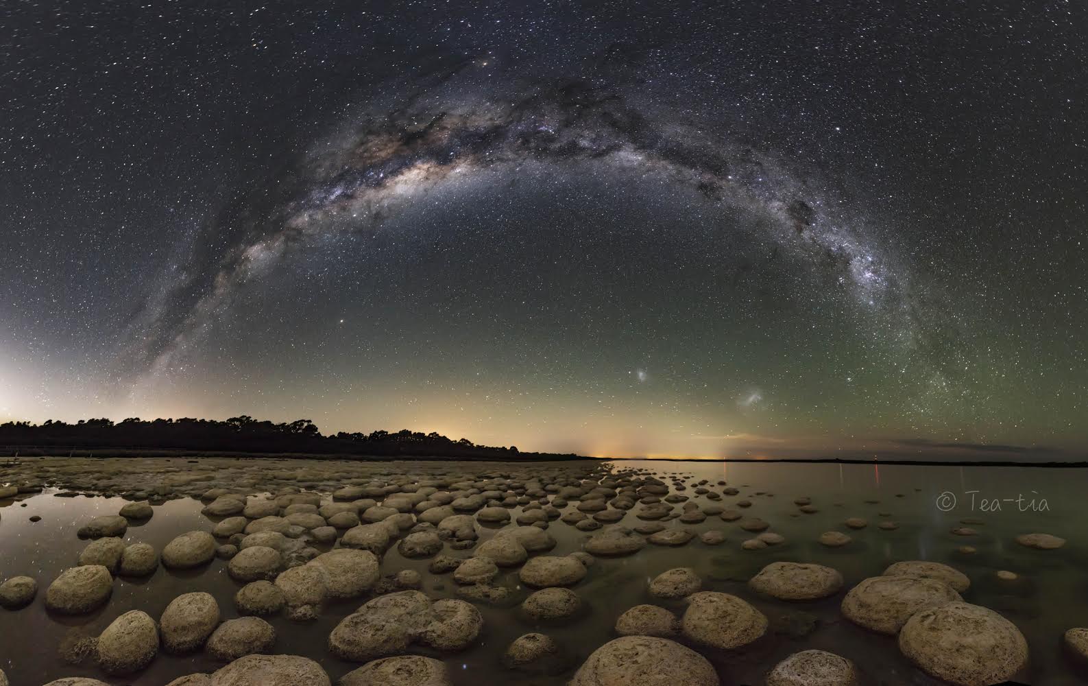 They may look like round rocks, but they're alive. Moreover, they are modern versions of one of the oldest known forms of life: stromatolites.  Fossils indicate that stromatolites appeared on Earth about 3.7 billion years ago -- even before many of the familiar stars in the modern night sky were formed.  In the featured image taken in Western Australia, only the ancient central arch of our Milky Way Galaxy formed earlier. Even the Magellanic Clouds, satellite galaxies of our Milky Way and visible in the featured image below the Milky Way's arch, didn't exist in their current form when stromatolites first grew on Earth. Stromatolites are accreting biofilms of billions of microorganisms that can slowly move toward light.  Using this light to liberate oxygen into the air, ancient stromatolites helped make Earth hospitable to other life forms including, eventually, humans.   Almost Hyperspace: Random APOD Generator