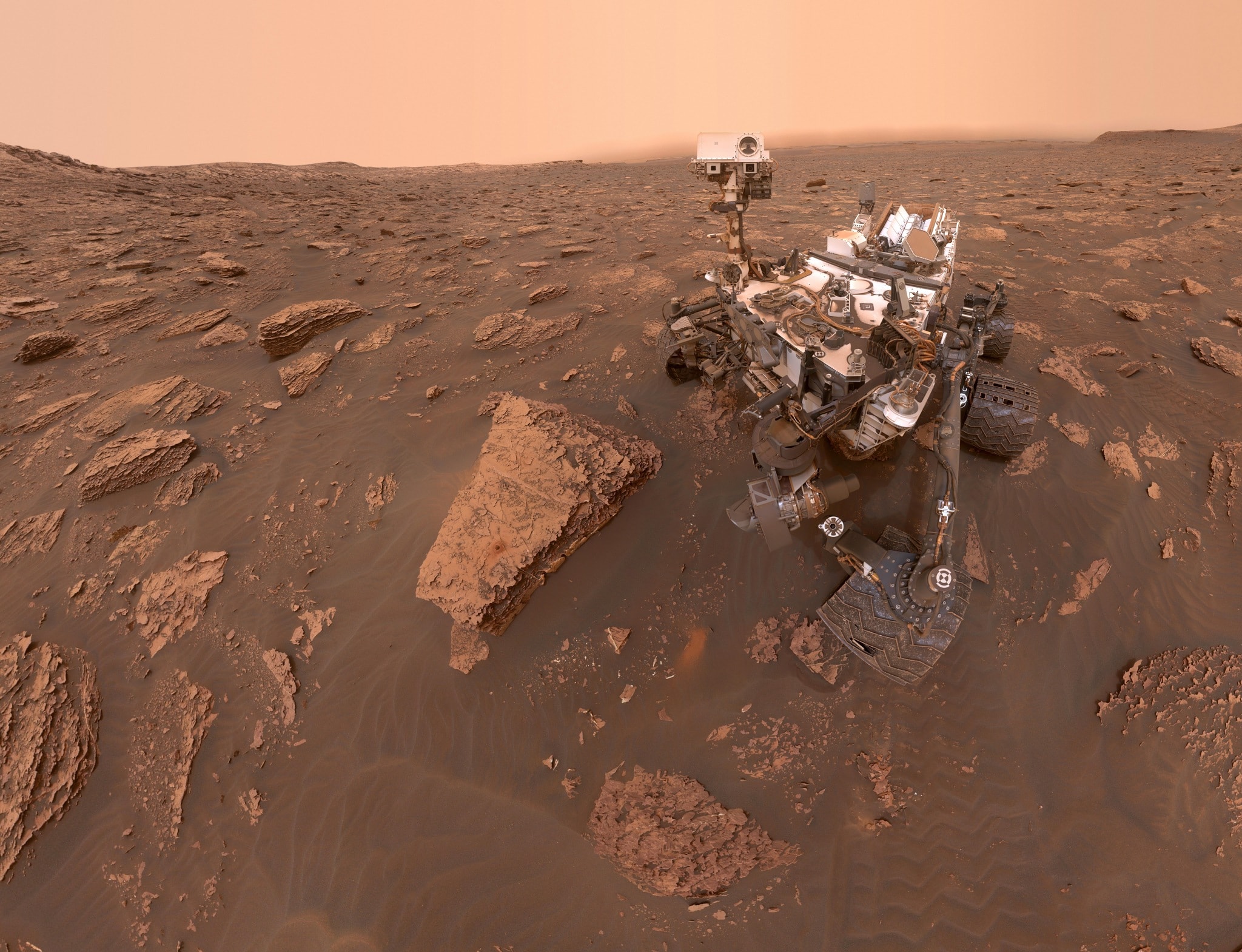 Winds on Mars can't actually blow spacecraft over. But in the low gravity, martian winds can loft fine dust particles in planet-wide storms, like the dust storm now raging on the Red Planet. From the martian surface on sol 2082 (June 15), this self-portrait from the Curiosity rover shows the effects of the dust storm, reducing sunlight and visibility at the rover's location in Gale crater. Made with the Mars Hand Lens Imager, its mechanical arm is edited out of the mosaicked images. Curiosity's recent drill site Duluth can be seen on the rock just in front of the rover on the left. The east-northeast Gale crater rim fading into the background is about 30 kilometers away. Curiosity is powered by a radioisotope thermoelectric generator and is expected to be unaffected by the increase in dust at Gale crater. On the other side of Mars, the solar-powered Opportunity rover has ceased its operations due to the even more severe lack of sunlight at its location on the west rim of Endeavour crater.