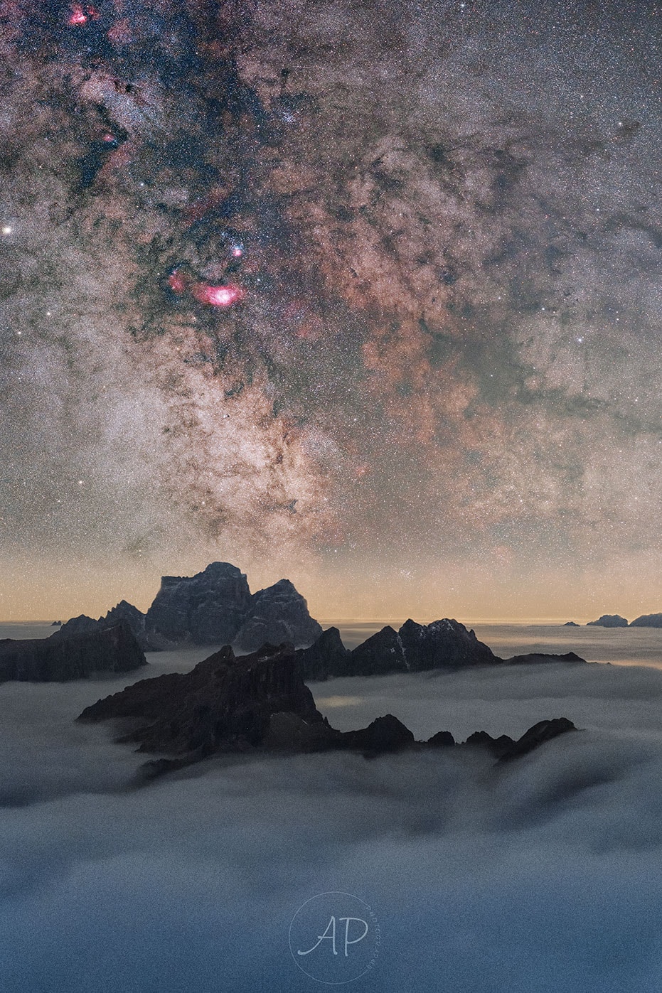 If you go high enough, you may find yourself on a picturesque perch between the water clouds of the Earth and the star clouds of the Milky Way.  Such was the case last month for one adventurous alpinist astrophotographer.  Captured here in the foreground above white clouds are mountain peaks in the Dolomite range in northern Italy. This multi-exposure image was captured from Lagazuoi, one of the Dolomites. Hundreds of millions of years ago, the Dolomites were not mountains but islands an ancient sea that rose through colliding tectonic plates. The Dolomites divergent history accounts for its unusually contrasting features, which include jagged crests and ancient marine fossils.  High above even the Dolomites, and far in the distance, dark dust lanes streak out from the central plane of our Milky Way Galaxy. The stars and dust are dotted with bright red clouds of glowing hydrogen gas -- such as the Lagoon Nebula just above and to the left of center.