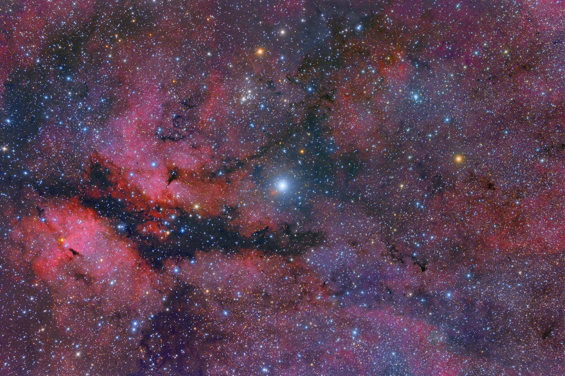 Supergiant star Gamma Cygni lies at the center of the Northern Cross, famous asterism in the constellation Cygnus the Swan. Known by its proper name, Sadr, the bright star also lies at the center of this gorgeous skyscape, featuring a complex of stars, dust clouds, and glowing nebulae along the plane of our Milky Way galaxy. The field of view spans almost 4 degrees (eight Full Moons) on the sky and includes emission nebula IC 1318 and open star cluster NGC 6910. Left of Gamma Cygni and shaped like two glowing cosmic wings divided by a long dark dust lane, IC 1318's popular name is understandably the Butterfly Nebula. Above and left of Gamma Cygni, are the young, still tightly grouped stars of NGC 6910. Some distance estimates for Gamma Cygni place it at around 1,800 light-years while estimates for IC 1318 and NGC 6910 range from 2,000 to 5,000 light-years.