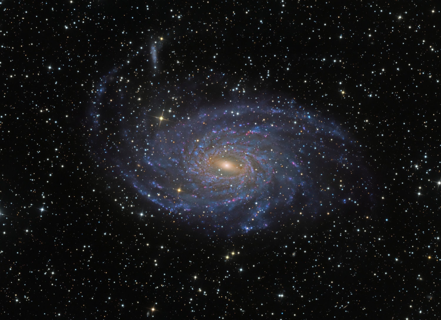 Beautiful spiral galaxy NGC 6744 is nearly 175,000 light-years across, larger than our own Milky Way. It lies some 30 million light-years distant in the southern constellation Pavo and appears as only a faint, extended object in small telescopes. We see the disk of the nearby island universe tilted towards our line of sight. This remarkably detailed galaxy portrait covers an area about the angular size of the full moon. In it, the giant galaxy's elongated yellowish core is dominated by the light from old, cool stars. Beyond the core, grand spiral arms are filled with young blue star clusters and speckled with pinkish star forming regions. An extended arm sweeps past a smaller satellite galaxy at the upper left. NGC 6744's galactic companion is reminiscent of the Milky Way's satellite galaxy the Large Magellanic Cloud.  This Weekend: Meteor showers expected, Moon bites Sun (again)