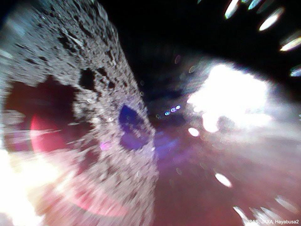 Two small robots have begun hopping around the surface of asteroid Ryugu. The rovers, each the size of a small frying pan, move around the low gravity of kilometer-sized 162173 Ryugu by hopping, staying aloft for about 15 minutes and typically landing again several meters away.  On Saturday, Rover 1A returned an early picture of its new home world, on the left, during one of its first hops. On Friday, lander MINERVA-II-1 detached from its mothership Hayabusa2, dropped Rovers 1A and 1B, and then landed on Ryugu. Studying Ryugu could tell humanity not only about Ryugu's surface and interior, but about what materials were available in the early Solar System for the development of life.  Two more hopping rovers are planned for release, and Hayabusa2 itself is scheduled to collect a surface sample from Ryugu and return it to Earth for detailed analysis before 2021.
