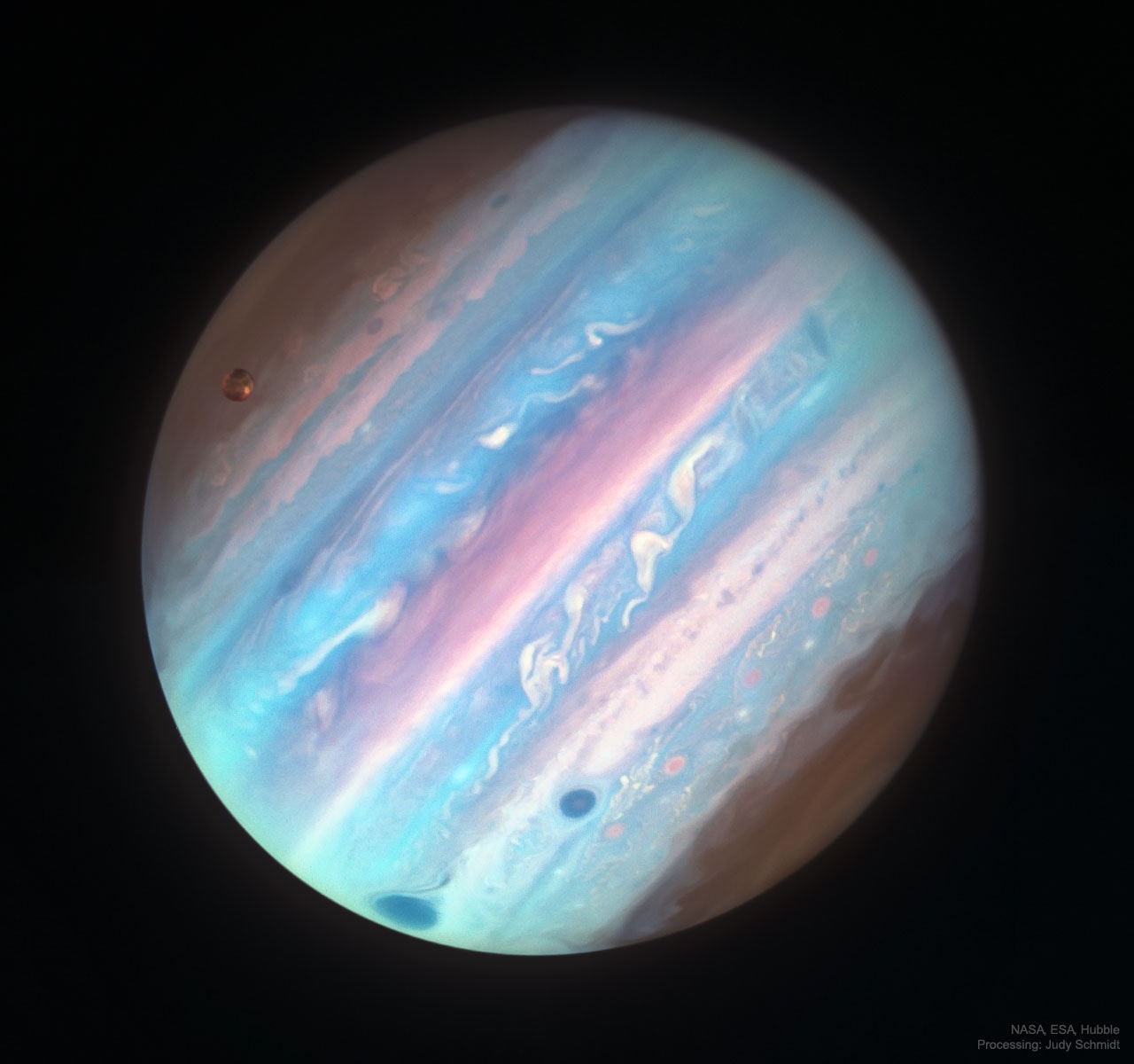 Jupiter looks a bit different in ultraviolet light.  To better interpret  Jupiter's cloud motions and to help NASA's robotic Juno spacecraft understand the planetary context of the small fields that it sees, the Hubble Space Telescope is being directed to regularly image the entire Jovian giant. The colors of Jupiter being monitored go beyond the normal human visual range to include both ultraviolet and (not pictured) infrared light.  Featured from 2017, Jupiter appears different in near ultraviolet light, partly because the amount of sunlight reflected back is distinct, giving differing cloud heights and latitudes discrepant brightnesses. In the near UV, Jupiter's poles appear relatively dark, as does its Great Red Spot and a smaller (optically) white oval to the right.  The String of Pearl storms farther to the right, however, are brightest in near ultraviolet, and so here appear (false-color) pink.  Jupiter's largest moon Ganymede appears on the upper left. Juno continues on its looping 53-day orbits around Jupiter, while Earth-orbiting Hubble is now recovering from the loss of a stabilizing gyroscope.