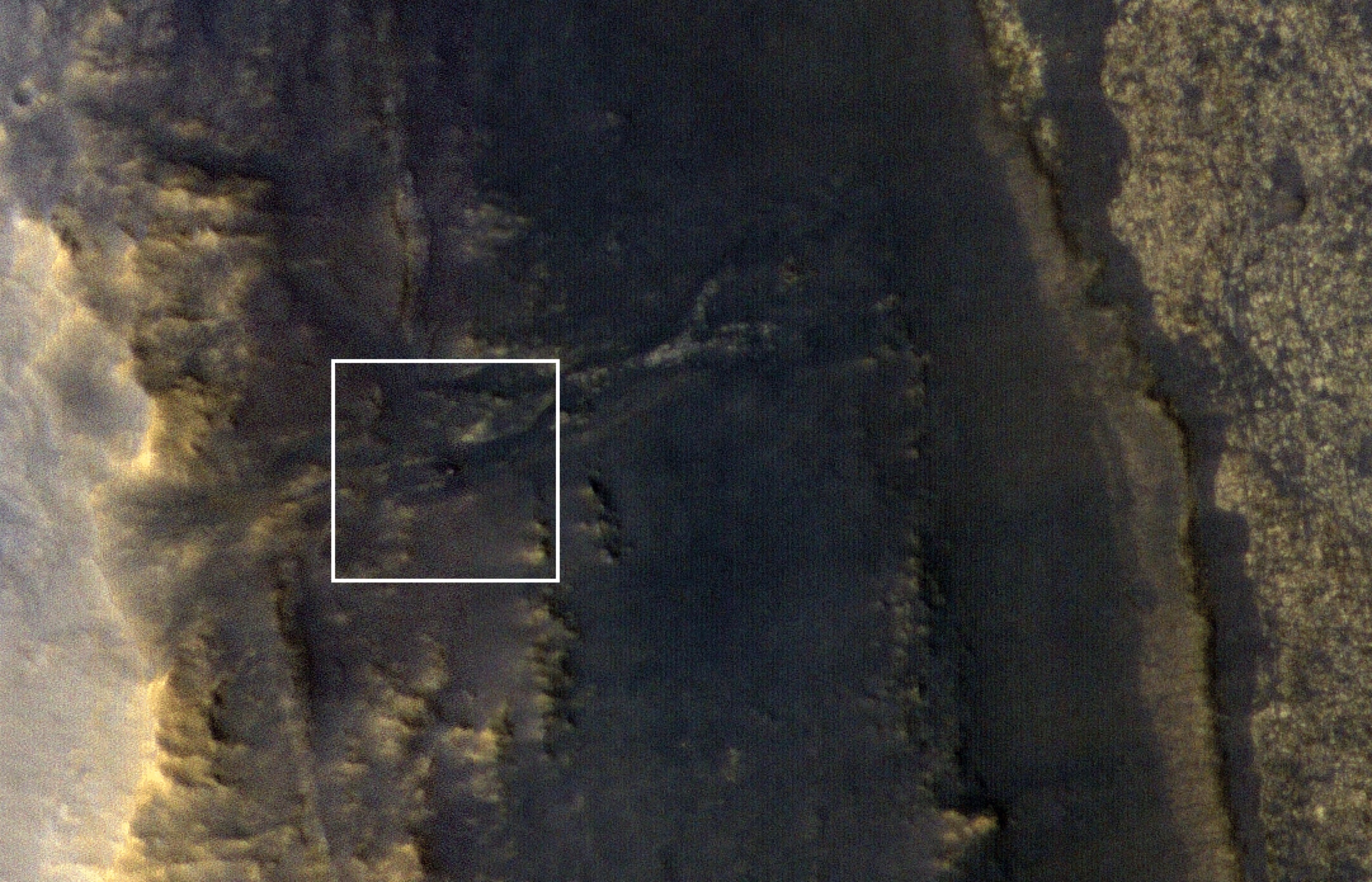 On Mars dust storms can't actually blow spacecraft over, but they can blot out the Sun. Over three months ago a planet-wide dust storm caused a severe lack of sunlight for the Mars rover Opportunity at its location near the west rim of Endeavour crater. The lack of sunlight sent the solar-powered Opportunity into hibernation and for over 115 sols controllers have not received any communication from the rover. The dust is clearing as the storm subsides though. On September 20th, when this image was taken by the Mars Reconnaissance Orbiter's HiRISE camera, about 25 percent of the sunlight was reaching the surface again. The white box marks a 47-meter-wide (154-foot-wide) area centered on a blip identified as the silent-for-now Opportunity rover.