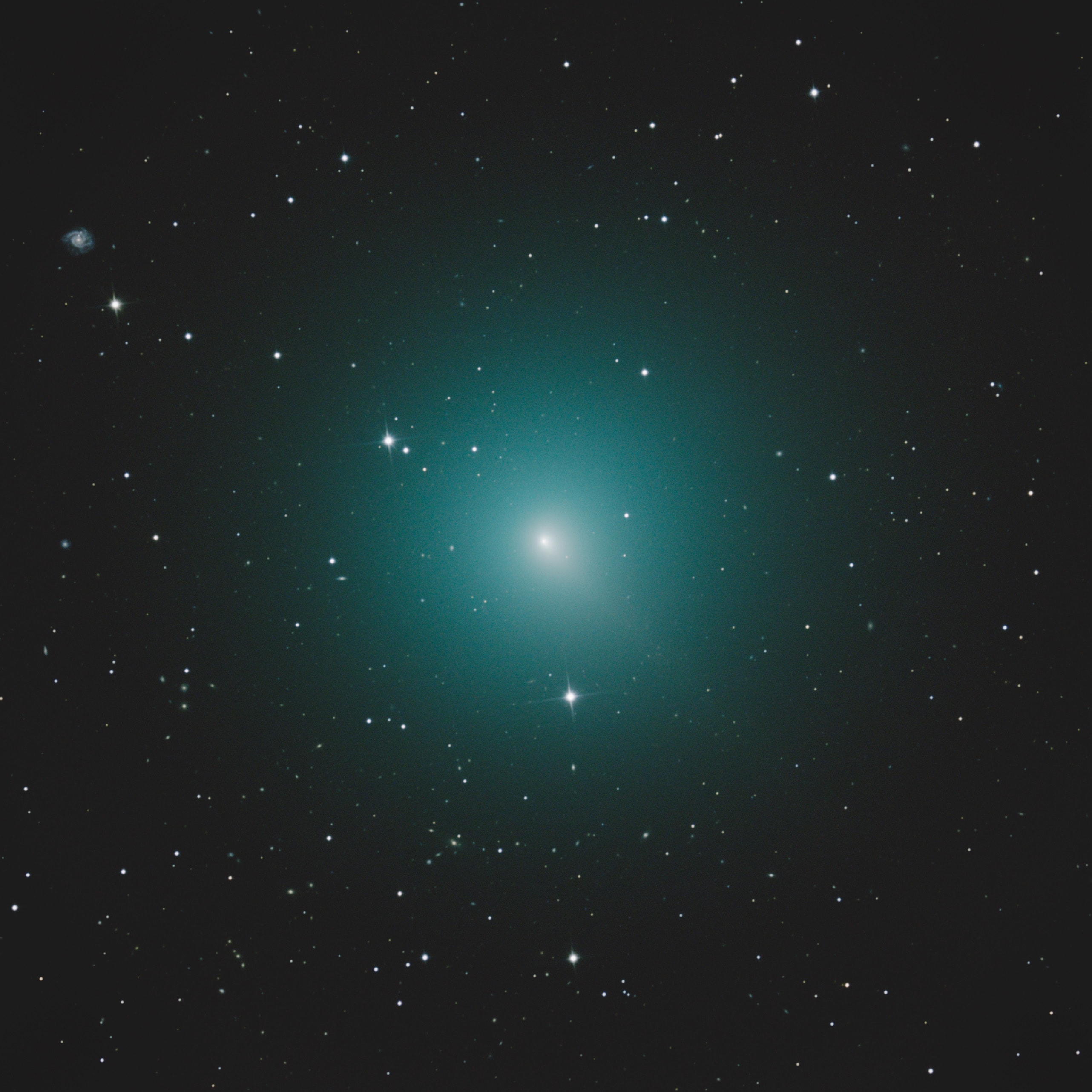 Periodic Comet 46P/Wirtanen is now the brightest comet in the night sky, but too faint to be seen by eye. From dark sky sites it could just become naked-eye visible though, as its 5.4 year long looping orbit takes it closest to Earth and the Sun in mid December. Fluorescing in sunlight, its spherical coma is about half the angular size of a full moon in this southern hemisphere telescopic view from November 7. Then the comet was about 2 light-minutes away or 35 million kilometers from Earth-bound telescopes, so the pretty greenish coma seen here is around 150,000 kilometers across. That makes it about the size of Jupiter. The stack of digital images also reveals a very faint tail extending toward 4 o'clock with a distant background galaxy notable at the upper left. As a regular visitor to the inner Solar System, comet 46P/Wirtanen was once the favored rendezvous target for ESA's comet exploring Rosetta mission.
