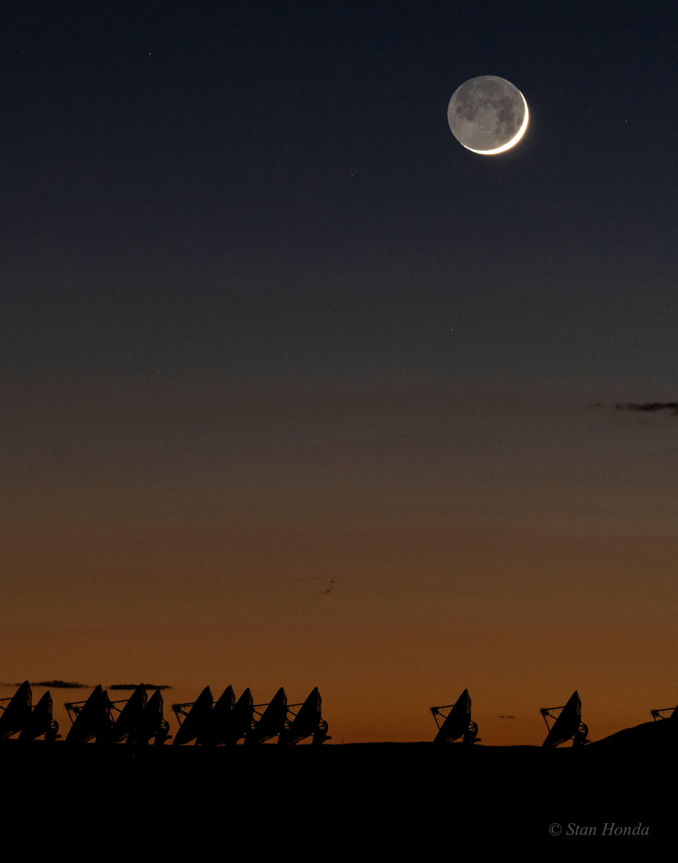 Tonight the Moon is young again, but this stunning image of a young Moon near the western horizon was taken just after sunset on October 10. On the lunar disk Earthshine, earthlight reflected from the Moon's night side, is embraced by the slim, sunlit crescent just over 2 days old. Along the horizon fading colors of twilight silhouette the radio telescope dish antennas of the Very Large Array, New Mexico, planet Earth. The view from the Moon would be stunning, too. When the Moon appears in Earth's sky as a slender crescent, a dazzlingly bright, nearly full Earth would be seen from the lunar surface. A description of earthshine, in terms of sunlight reflected by Earth's oceans in turn illuminating the Moon's dark surface, was written 500 years ago by Leonardo da Vinci.