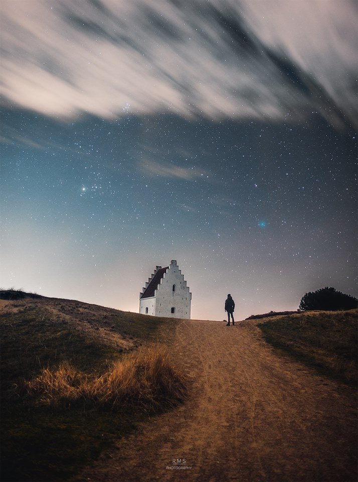 Today Comet Wirtanen passes by the Earth. The kilometer-sized dirty snowball orbits the Sun every 5.4 years, ranging as far out as Jupiter and as close in as the Earth. Today Comet 46P/Wirtanen passes within only 31 lunar distances to the Earth, the closest approach in 70 years.  If you know where to look (Taurus), you can see the comet through binoculars as an unusual blue smudge.  Pictured a week ago, Comet Wirtanen was photographed in the sky beyond an old abandoned church in Skagen, Denmark.  The image composite also captures the astrophotographer.  After today, the comet will begin to fade as it recedes from the Earth and the Sun.   Free Download: 2019 APOD Calendar (v5)