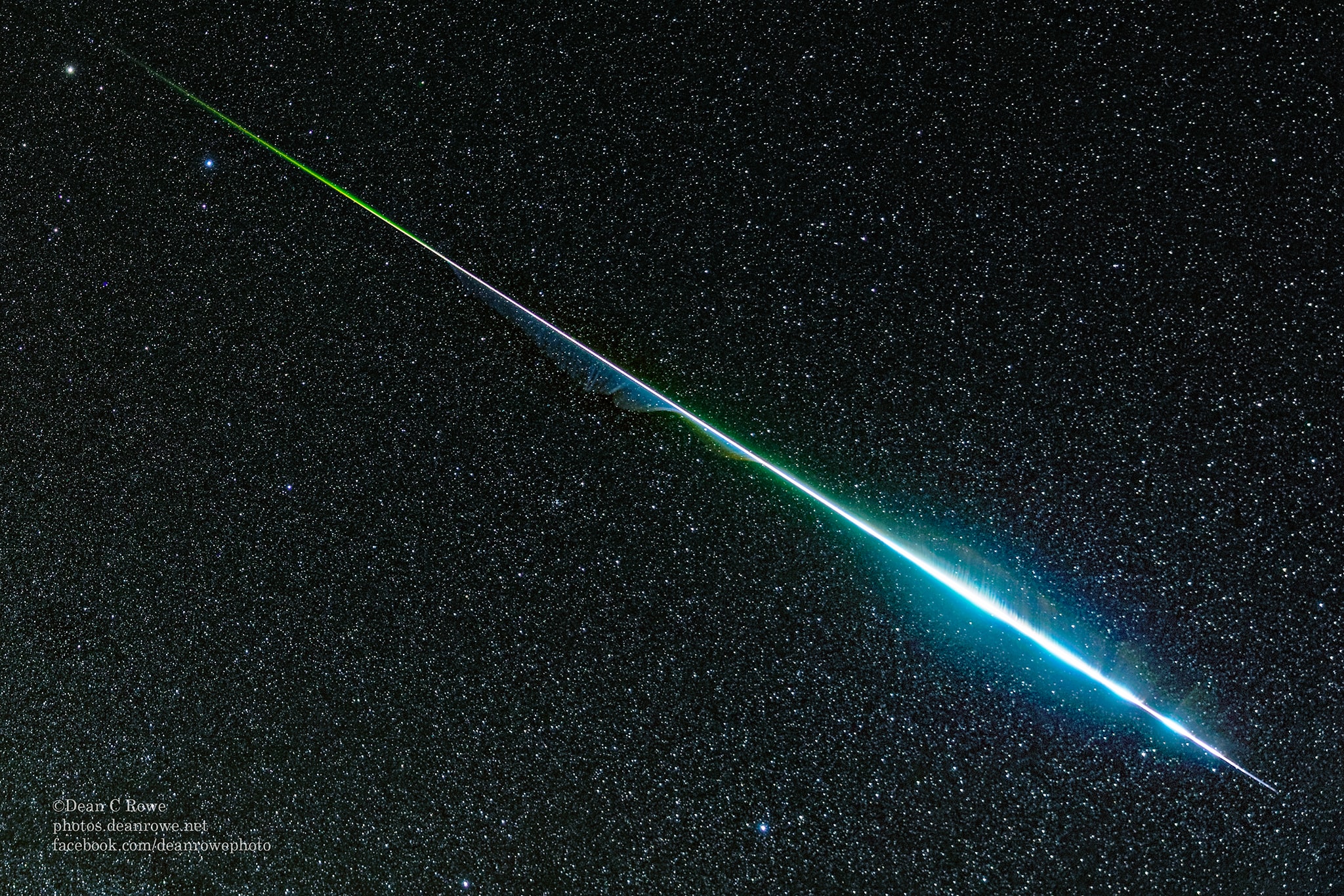 Meteors can be colorful. While the human eye usually cannot discern many colors, cameras often can. Pictured is a Geminid captured by camera during last week's meteor shower that was not only impressively bright, but colorful. The radiant grit cast off by asteroid 3200 Phaethon blazed a path across Earth's atmosphere longer than 60 times the angular diameter of the Moon. Colors in meteors usually originate from ionized elements released as the meteor disintegrates, with blue-green typically originating from magnesium, calcium radiating violet, and nickel glowing green. Red, however, typically originates from energized nitrogen and oxygen in the Earth's atmosphere.  This bright meteoric fireball was gone in a flash -- less than a second -- but it left a wind-blown ionization trail that remained visible for several minutes, the start of which can be seen here.   Gallery: Geminid Meteors 2018