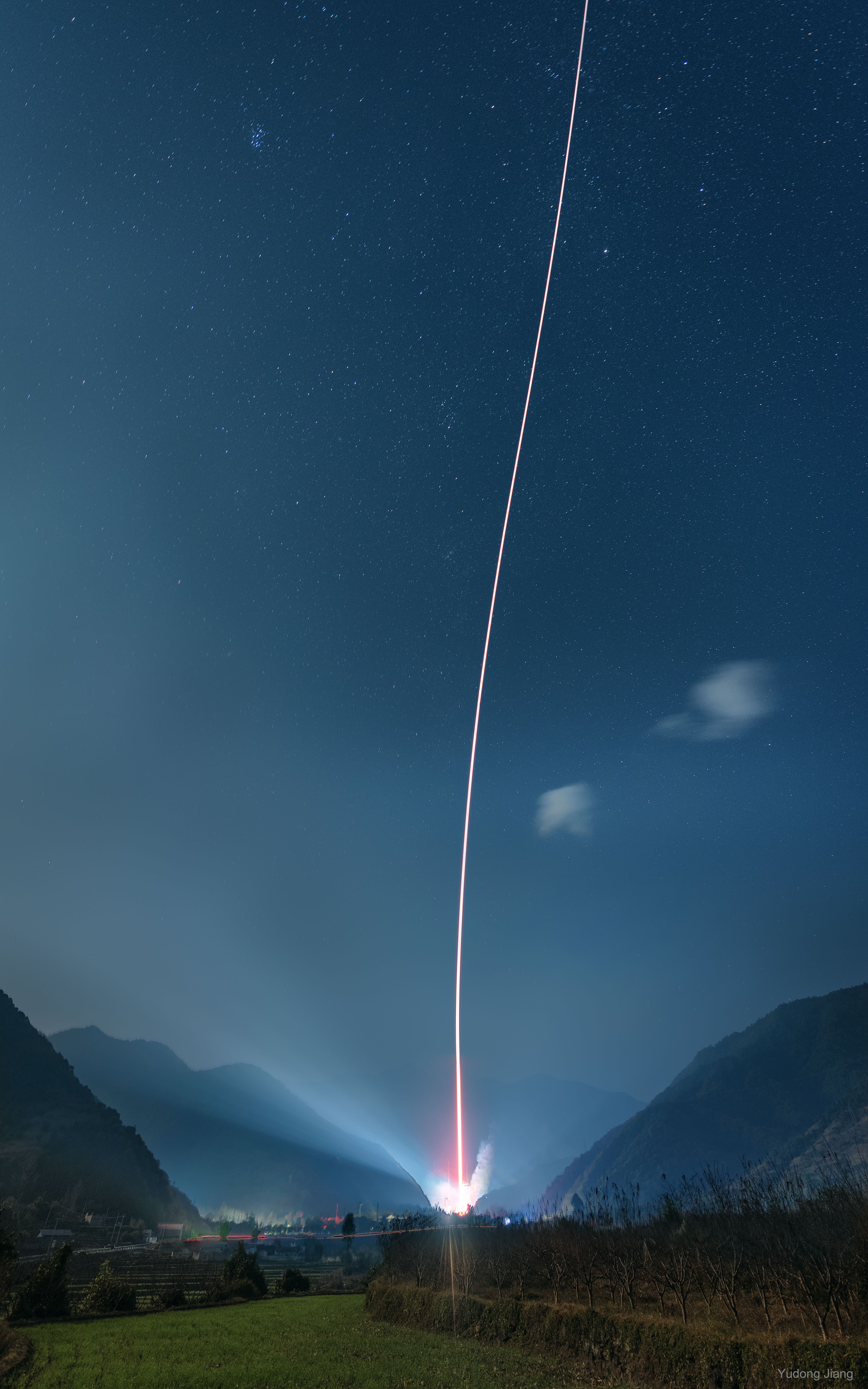 What's happening between those mountains? A rocket is being launched to space. Specifically, a Long March 3B Carrier Rocket was launched from Xichang Satellite Launch Center in Sichuan Province in China about two week ago.  The rocket lifted two navigation satellites to about 2,000 kilometers above the Earth's surface, well above the orbit of the International Space Station, but well below the orbit of geostationary satellites.  China's Chang'e 3 mission that landed the robotic Yutu rover on the Moon was launched from Xichang in 2013.  The featured image was taken about 10 kilometers from the launch site and is actually a composite of nine exposures, including a separate background image.