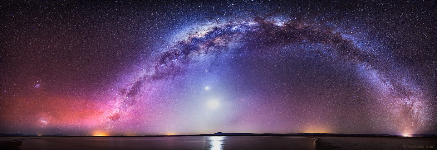 There is a road that connects the Northern to the Southern Cross but you have to be at the right place and time to see it. The road, as pictured here, is actually the central band of our Milky Way Galaxy; the right place, in this case, is dark Laguna Cejar in Salar de Atacama of Northern Chile; and the right time was in early October, just after sunset. Many sky wonders were captured then, including the bright Moon, inside the Milky Way arch;  Venus, just above the Moon; Saturn and Mercury, just below the Moon; the Large and Small Magellanic Clouds satellite galaxies, on the far left; red airglow near the horizon on the image left; and the lights of small towns at several locations across the horizon.  One might guess that composing this 30-image panorama would have been a serene experience, but for that one would have required earplugs to ignore the continued brays of wild donkeys.
