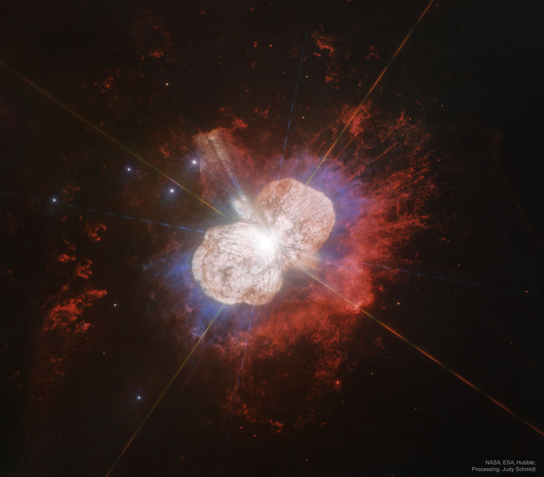 Carinae may be about to explode.  But no one knows when - it may be next year, it may be one million years from now. Eta Carinae's mass - about 100 times greater than our Sun - makes it an excellent candidate for a full blown supernova. Historical records do show that about 170 years ago Eta Carinae underwent an unusual outburst that made it one of the brightest stars in the southern sky.  Eta Carinae, in the Keyhole Nebula, is the only star currently thought to emit natural LASER light. This featured image brings out details in the unusual nebula that surrounds this rogue star.  Diffraction spikes, caused by the telescope, are visible as bright multi-colored streaks emanating from Eta Carinae's center.  Two distinct lobes of the Homunculus Nebula encompass the hot central region, while some strange radial streaks are visible in red extending toward the image right. The lobes are filled with lanes of gas and dust which absorb the blue and ultraviolet light emitted near the center.  The streaks, however, remain unexplained.