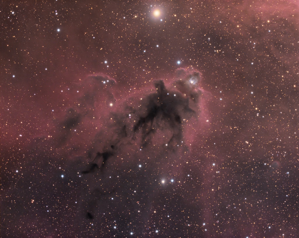 The silhouette of an intriguing dark nebula inhabits this cosmic scene. Lynds' Dark Nebula (LDN) 1622 appears against a faint background of glowing hydrogen gas only easily seen in long telescopic exposures of the region. LDN 1622 lies near the plane of our Milky Way Galaxy, close on the sky to Barnard's Loop, a large cloud surrounding the rich complex of emission nebulae found in the Belt and Sword of Orion. But the obscuring dust of LDN 1622 is thought to be much closer than Orion's more famous nebulae, perhaps only 500 light-years away. At that distance, this 1 degree wide field of view would span less than 10 light-years. Its foreboding appearance lends this dark expanse a popular name, the Boogeyman Nebula.