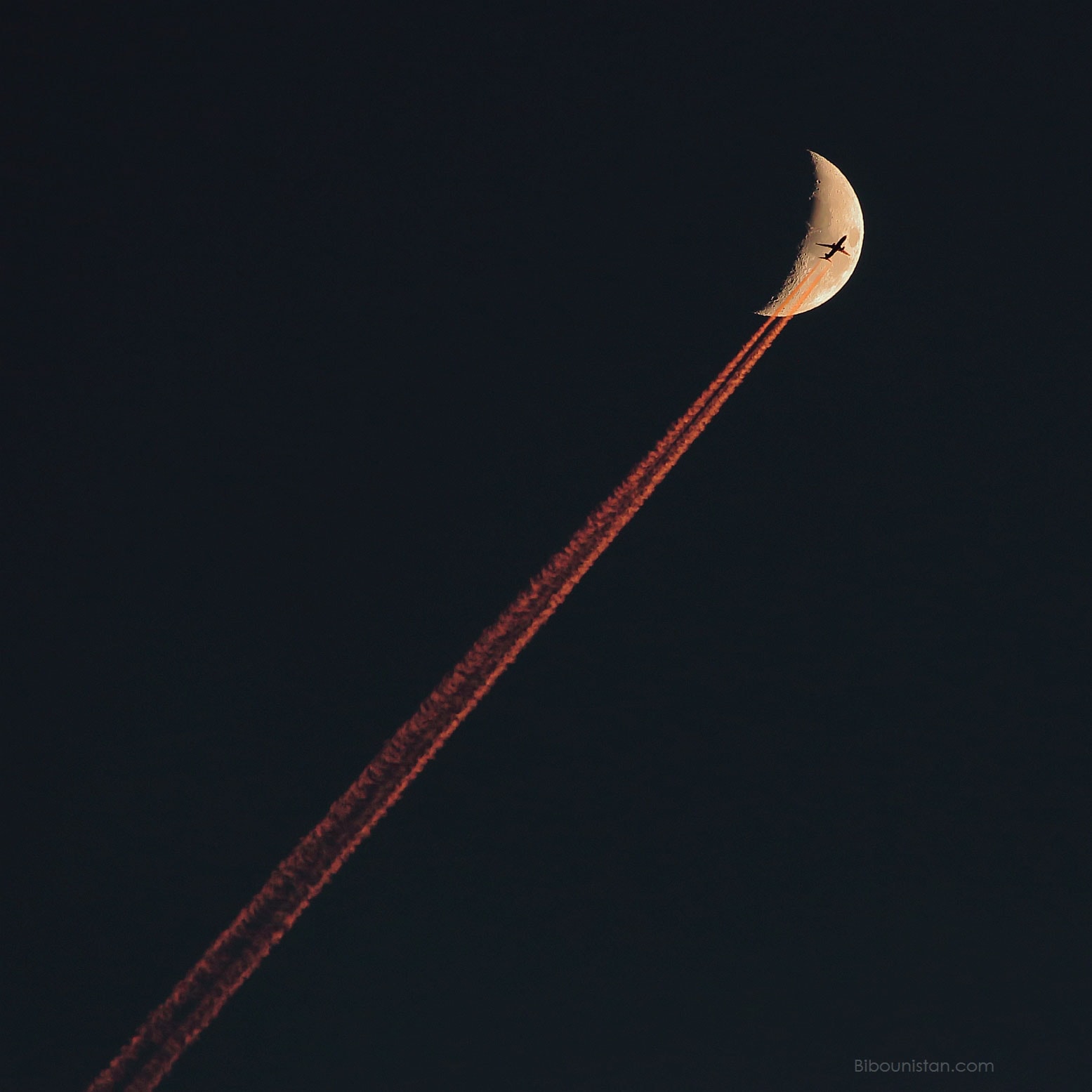 No, this is not a good way to get to the Moon. What is pictured is a chance superposition of an airplane and the Moon. The contrail would normally appear white, but the large volume of air toward the setting Sun preferentially knocks away blue light, giving the reflected trail a bright red hue.  Far in the distance, well behind the plane, is a crescent Moon, also slightly reddened.  Captured a month ago above Valais, Switzerland, the featured image was taken so soon after sunset that planes in the sky were still in sunlight, as were their contrails. Within minutes, unfortunately, the impromptu sky show ended.  The plane crossed the Moon and moved out of sight.  The Moon set.  The contrail became unilluminated and then dispersed.