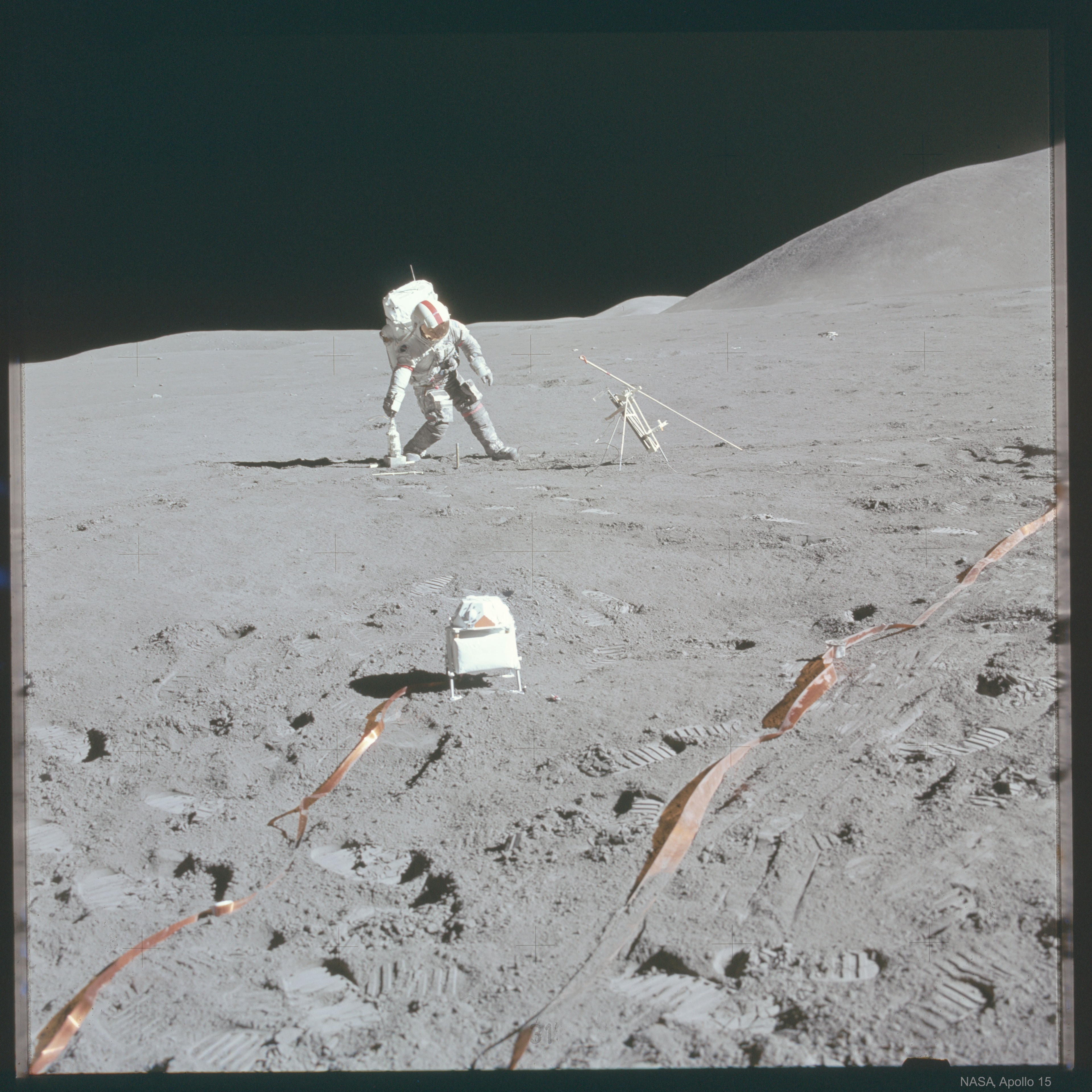 Score three points for NASA.  With time running out late in Apollo 15's mission to the Moon in 1971, Astronaut David Scott prepared to split the uprights and bring about yet another dramatic end-of-the-mission victory for NASA.  Scott used a special  lunar football designed for the rugged games held on the Moon.  R1-D1, a predecessor to R2-D2, cheered from the sideline.  Happy April Fools' Day from the folks at APOD.  In reality, Astronaut Scott placed a drill that measured how temperature changed with lunar depth.  The foreground device actually detected high-energy particles that escaped from the Sun.   No Joke: NASA Plans to Return to the Moon in the Next Five Years