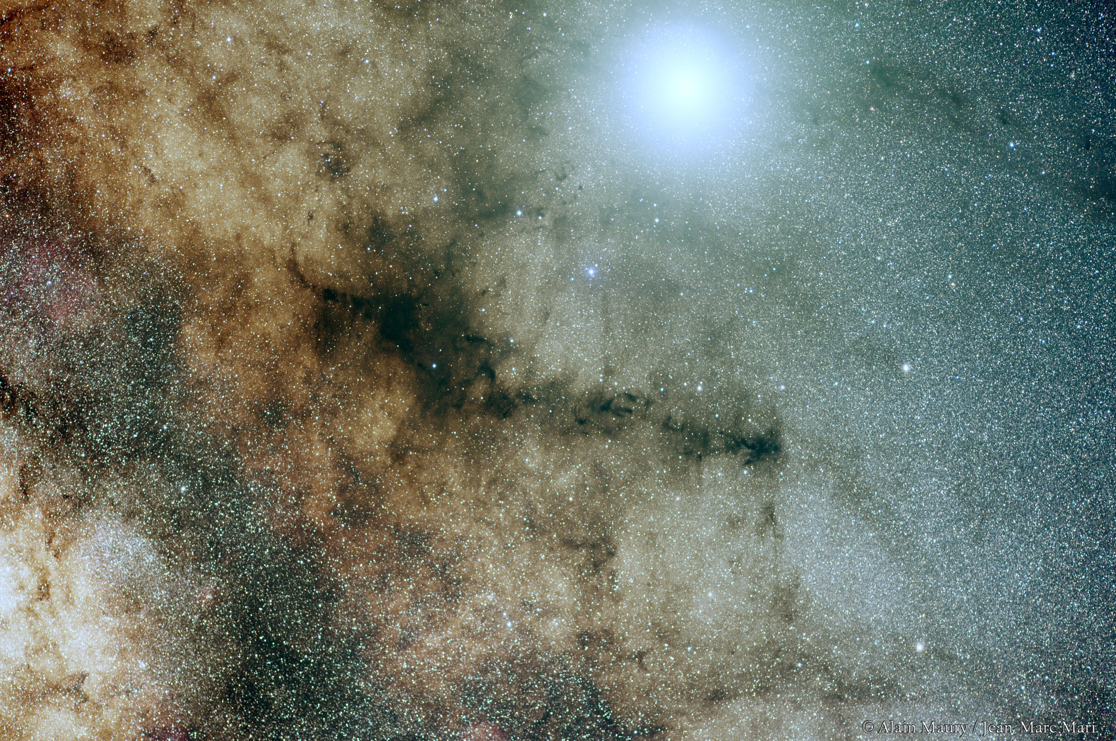 Now posing against our galaxy's rich starfields and nebulae, brilliant planet Jupiter shines in the night sky. Its almost overwhelming glow is near the top of the frame in this colorful telephoto portrait of the central Milky Way. Spanning about 20 degrees on the sky, the scene includes the silhouette of LDN 1773 against the starlight, also know by the popular moniker the Pipe Nebula for its apparent outline of stem and bowl. The Pipe Nebula is part of the galaxy's Ophiuchus dark cloud complex. Located at a distance of about 450 light-years, dense cores of gas and dust within are collapsing to form stars.  Approaching its opposition, opposite the Sun in the sky on June 10, Jupiter is only about 36 light-minutes from planet Earth. Fans of dark markings on the sky can probably spot the Snake Nebula below and left of Jupiter's glare.