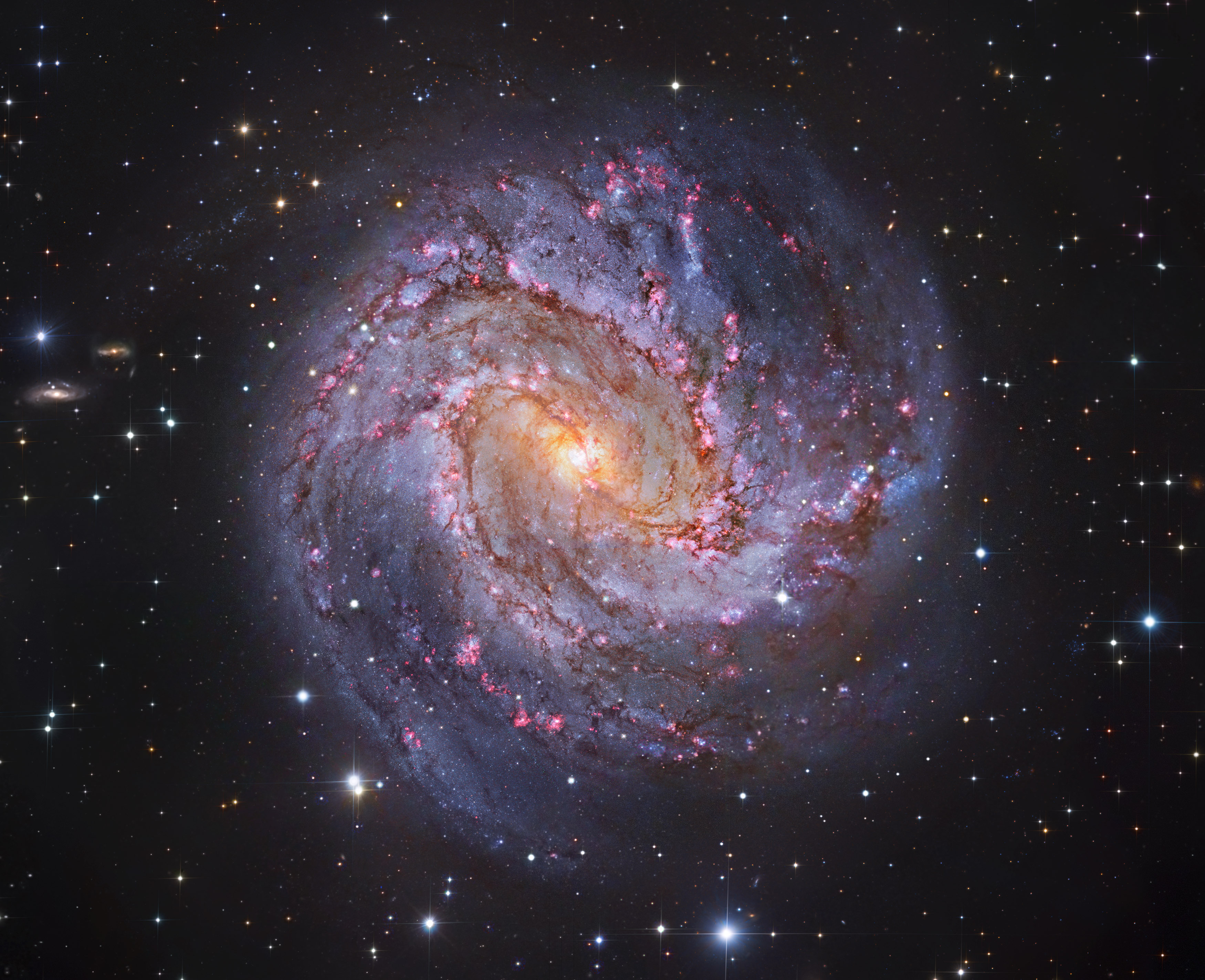 Big, bright, and beautiful, spiral galaxy M83 lies a mere twelve million light-years away, near the southeastern tip of the very long constellation Hydra. Prominent spiral arms traced by dark dust lanes and blue star clusters lend this galaxy its popular name, The Southern Pinwheel.  But reddish star forming regions that dot the sweeping arms highlighted in this sparkling color composite also suggest another nickname, The Thousand-Ruby Galaxy. About 40,000 light-years across, M83 is a member of a group of galaxies that includes active galaxy Centaurus A. In fact, the core of M83 itself is bright at x-ray energies, showing a high concentration of neutron stars and black holes left from an intense burst of star formation. This sharp composite color image also features spiky foreground Milky Way stars and distant background galaxies. The image data was taken from the Subaru Telescope, the European Southern Observatory's Wide Field Imager camera, and the Hubble Legacy Archive.