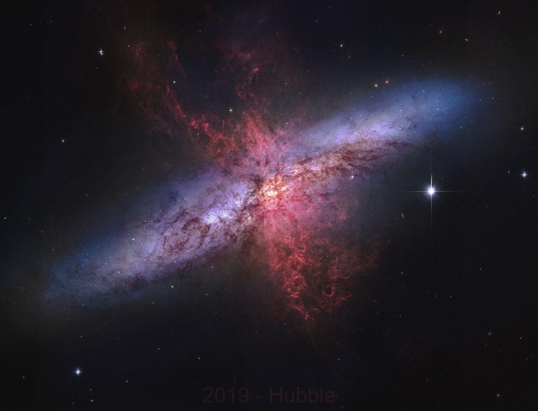 Why is the Cigar Galaxy billowing red smoke?  M82, as this starburst galaxy is also known, was stirred up by a recent pass near large spiral galaxy M81.  This doesn't fully explain the source of the red-glowing outwardly expanding gas and dust, however.  Evidence indicates that this gas and dust is being driven out by the combined emerging particle winds of many stars, together creating a galactic superwind.  The dust particles are thought to originate in M82's interstellar medium and are actually similar in size to particles in cigar smoke.  The featured photographic mosaic highlights a specific color of red light strongly emitted by ionized hydrogen gas, showing detailed filaments of this gas and dust.  The filaments extend for over 10,000 light years. The 12-million light-year distant Cigar Galaxy is the brightest galaxy in the sky in infrared light, and can be seen in visible light with a small telescope towards the constellation of the Great Bear (Ursa Major).   APOD in other languages: Arabic, Catalan, Chinese (Beijing), Chinese (Taiwan), Croatian, Czech, Dutch, Farsi, French, French, German, Hebrew, Indonesian, Japanese, Korean, Montenegrin, Polish, Russian, Serbian, Slovenian,  Spanish and Ukrainian